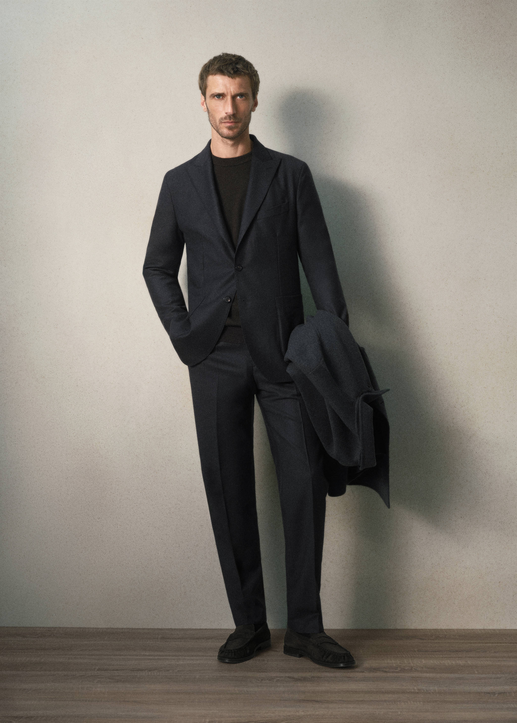 Navy blue blazer worn with matching trousers and a dark jumper.