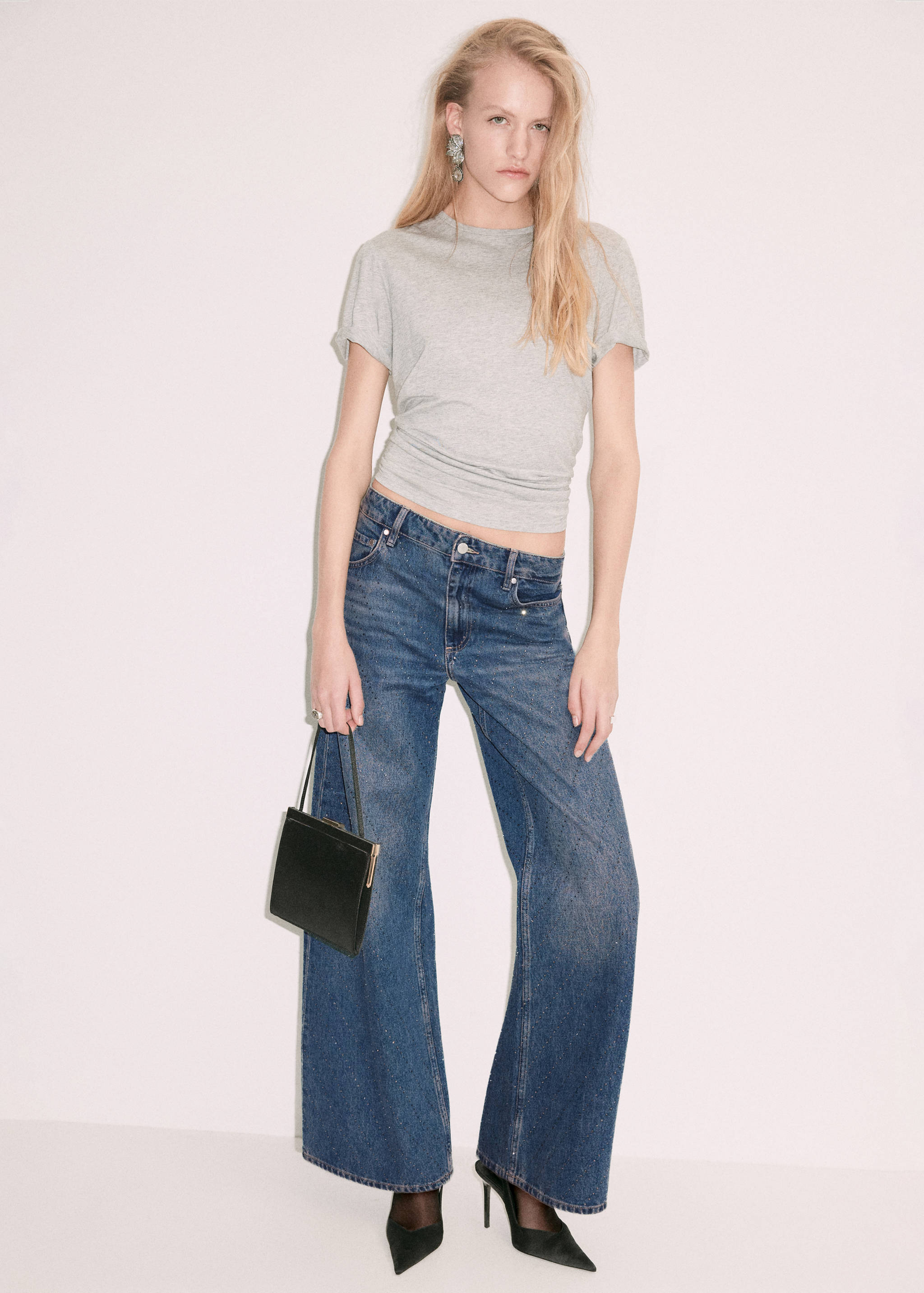 Dark blue low-rise wide-leg denim trousers worn with a grey t-shirt.