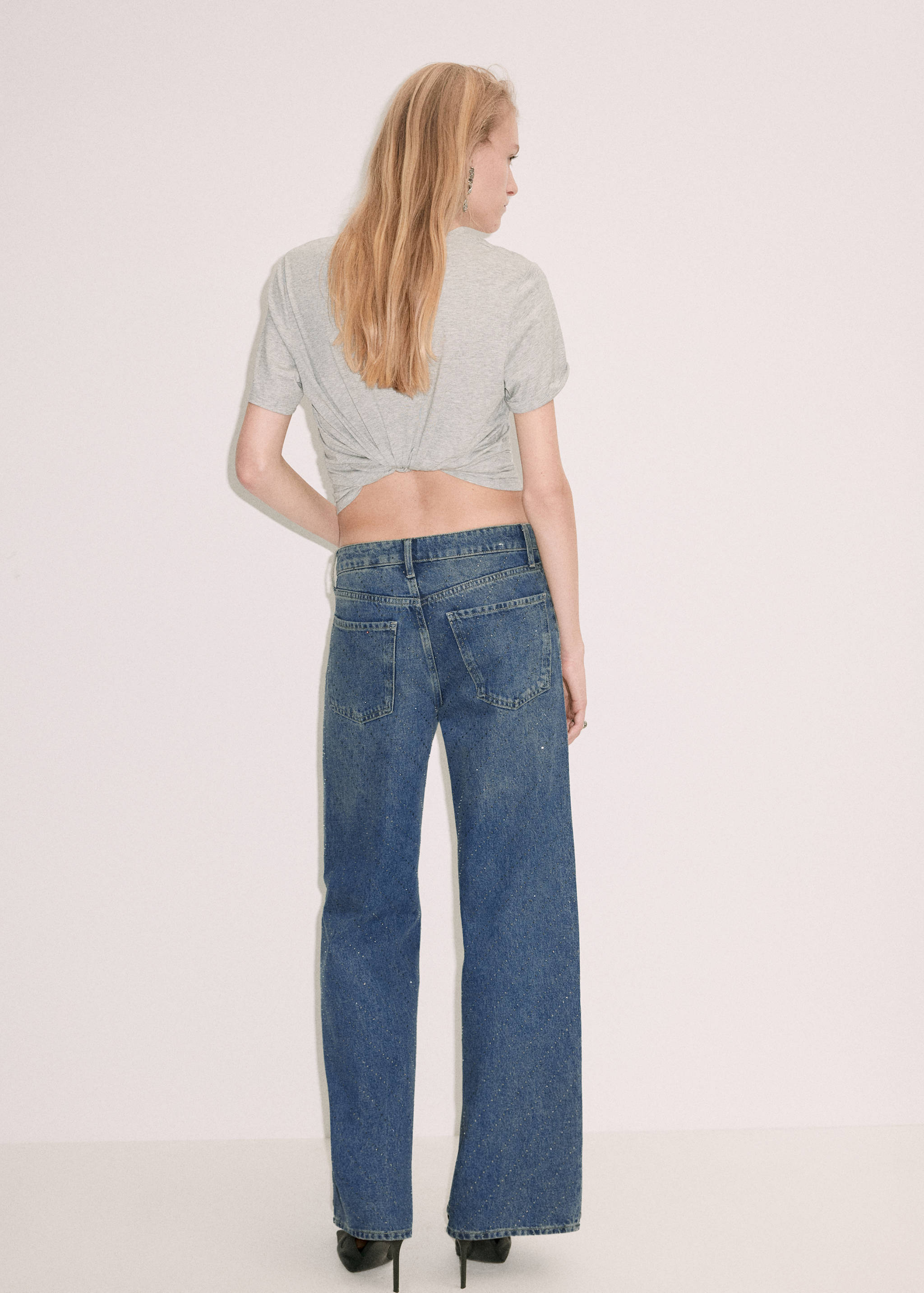 Medium-wash blue denim trousers, back view.