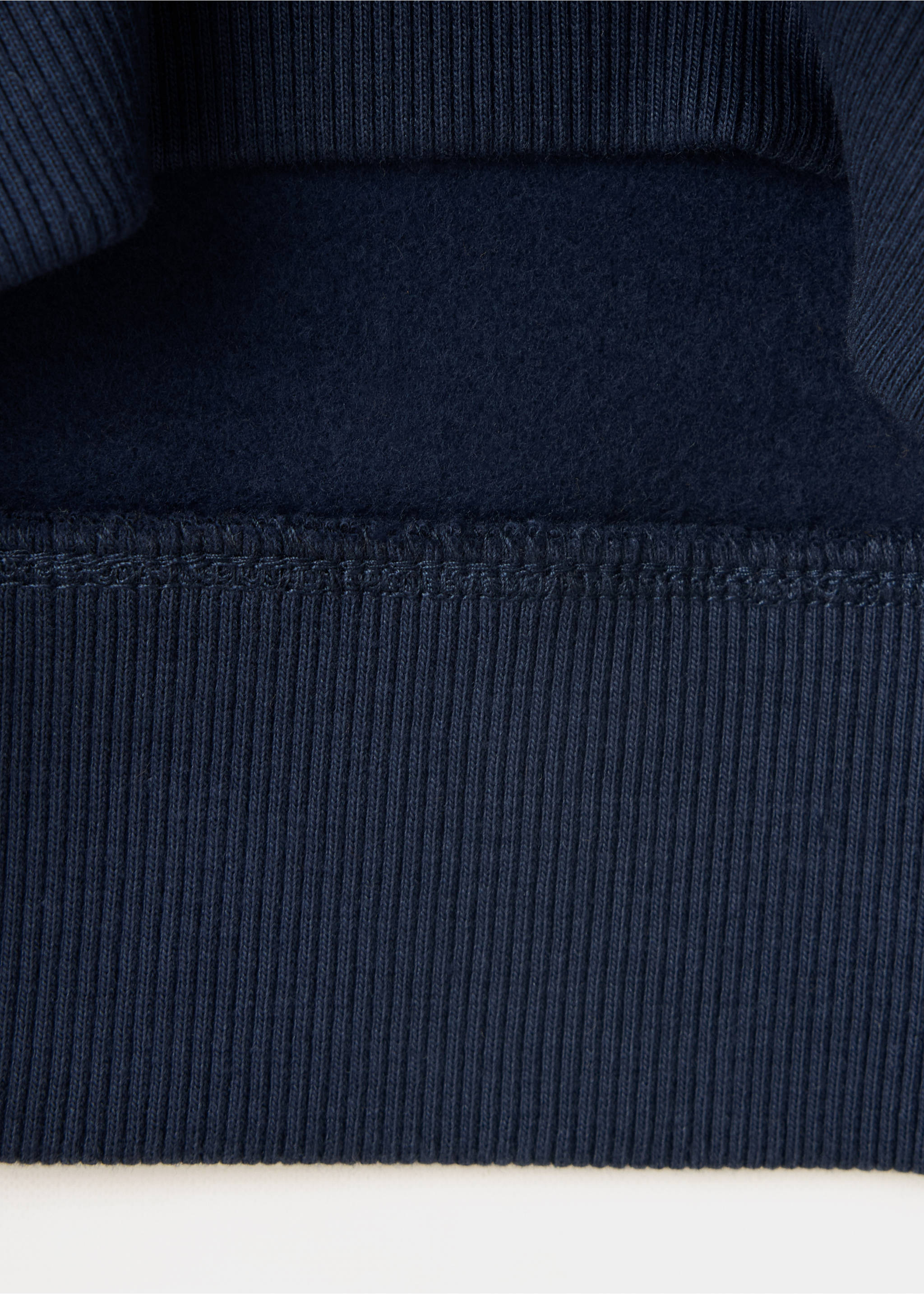 Close-up of navy blue sweatshirt fabric texture and ribbed hem., Navy. Ref: 37038633-00.