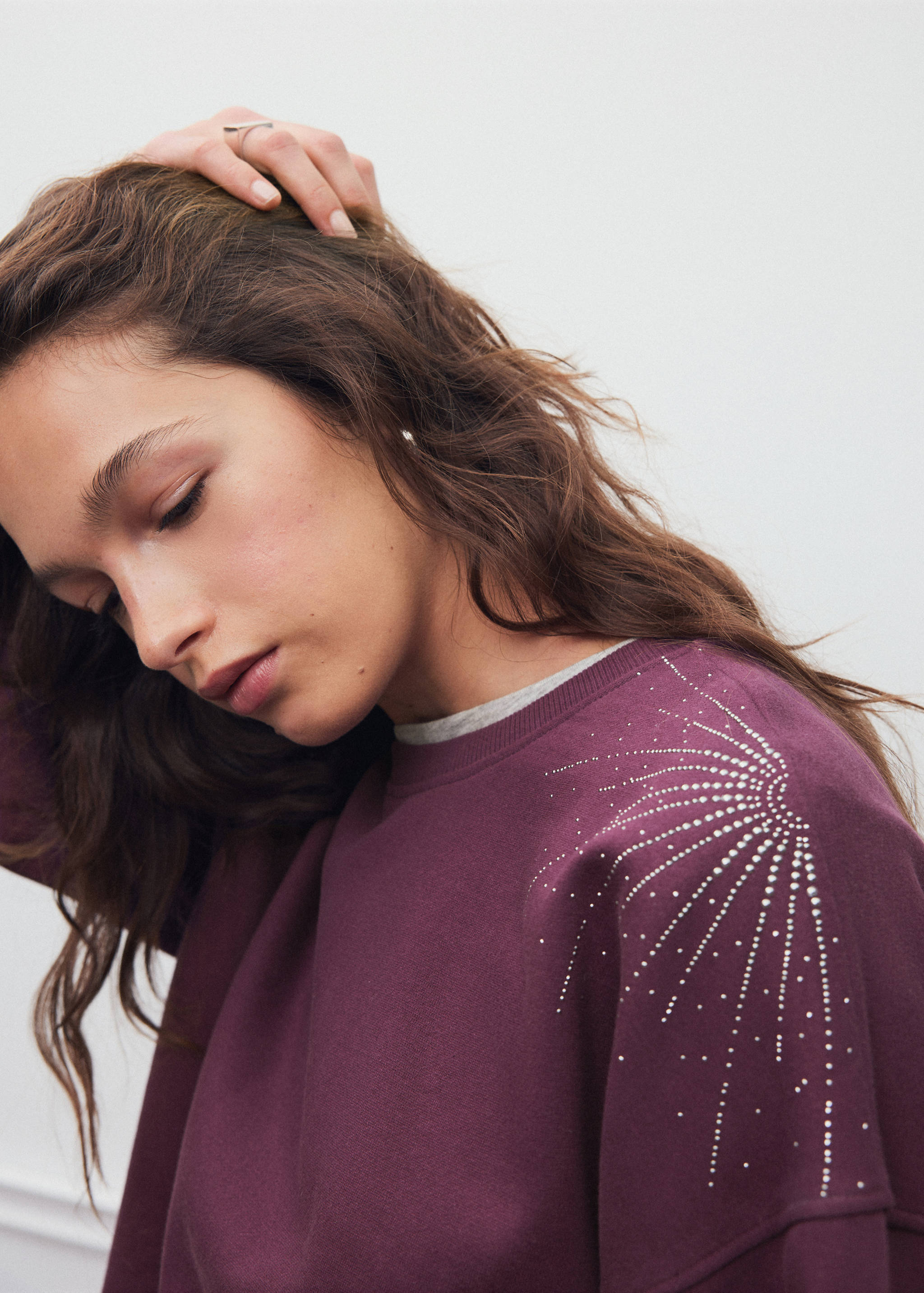 Burgundy sweatshirt with rhinestone shoulder detail.