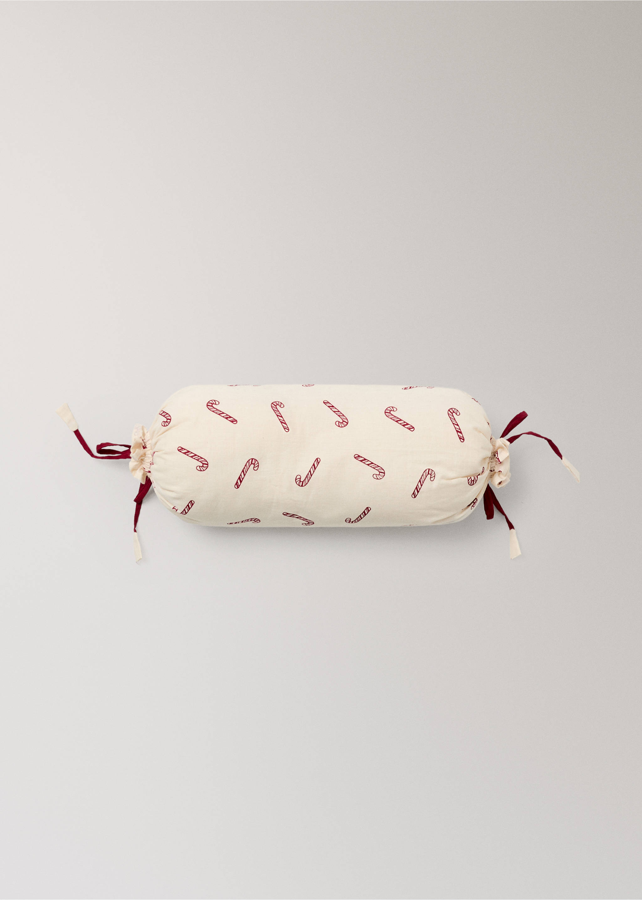 Cream cylindrical cushion with red candy cane print and tied ends., Red. Ref: 37038636-00.