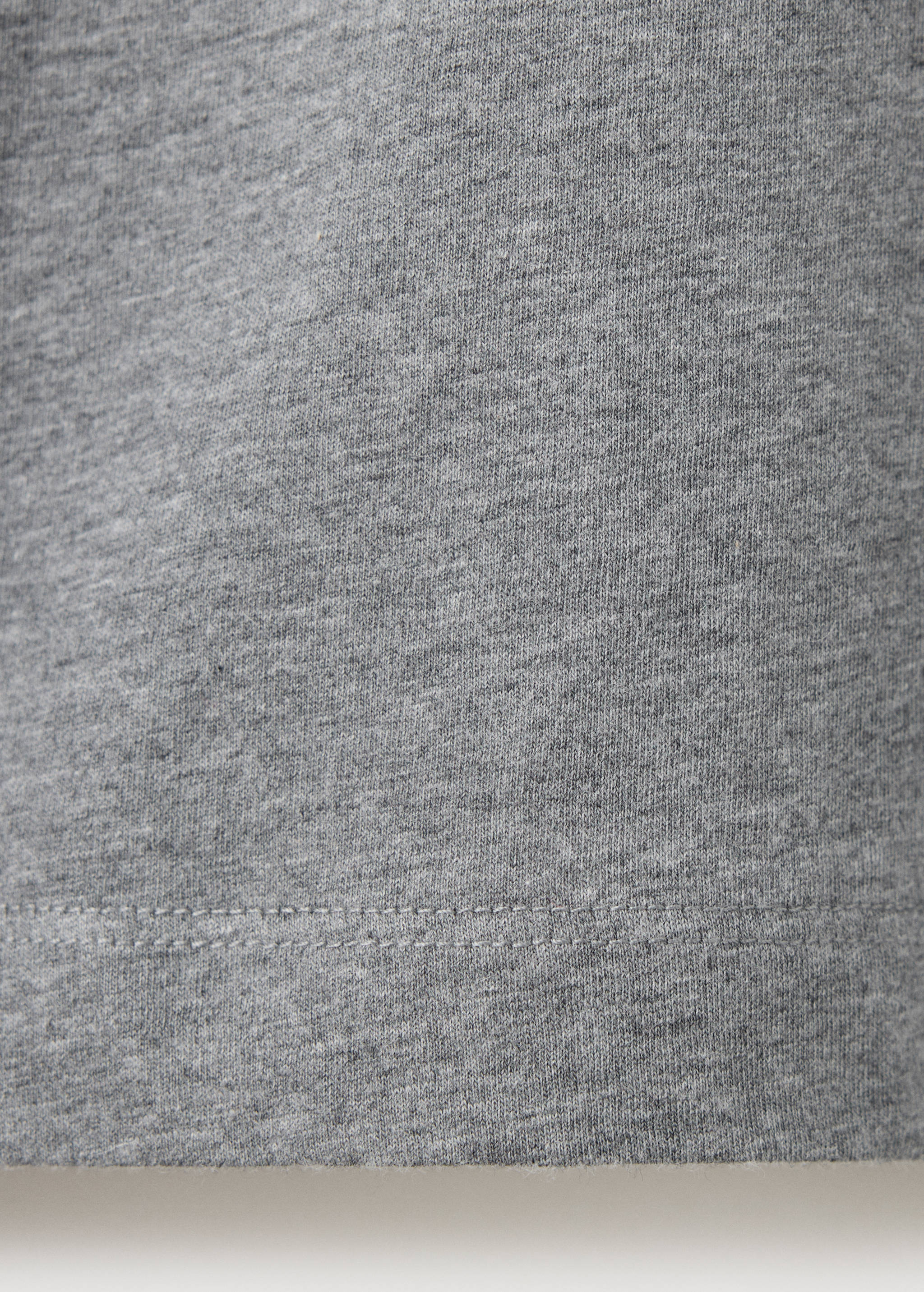 Close-up of grey melange t-shirt fabric texture and hem.