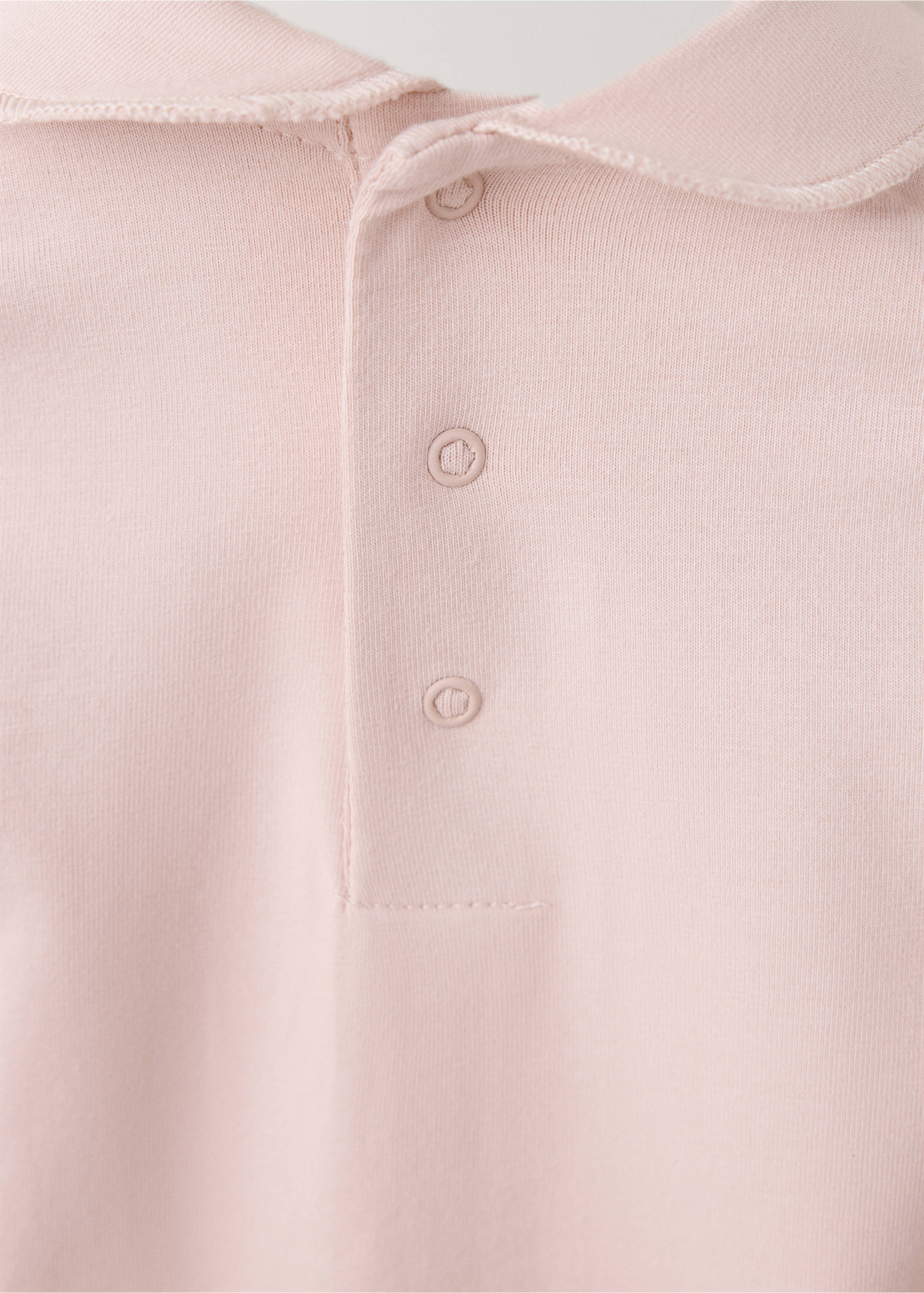 Pink baby pyjama detail showing a rounded collar and button placket, Red. Ref: 37038639-00.