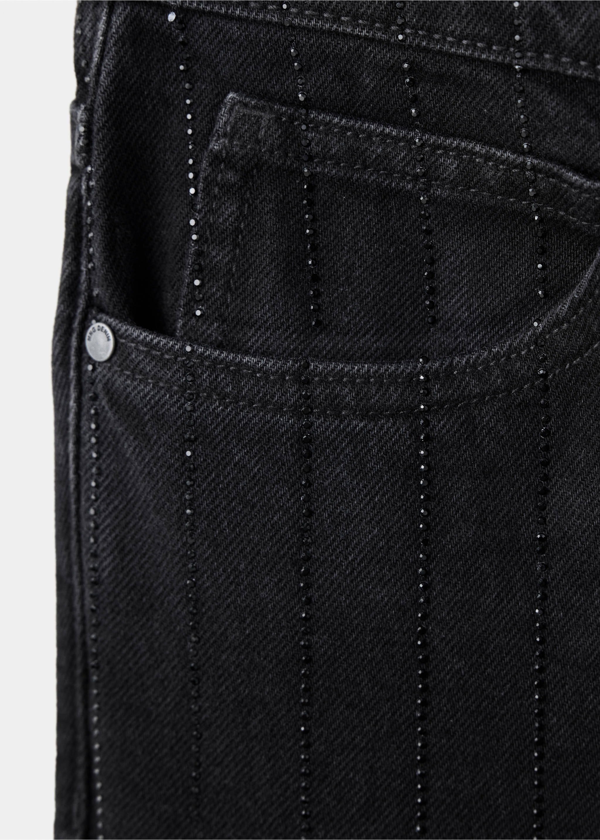 Primer plano del detalle de unos pantalones vaqueros negros con pedrería., Denim negro. Ref: 37039116-00.