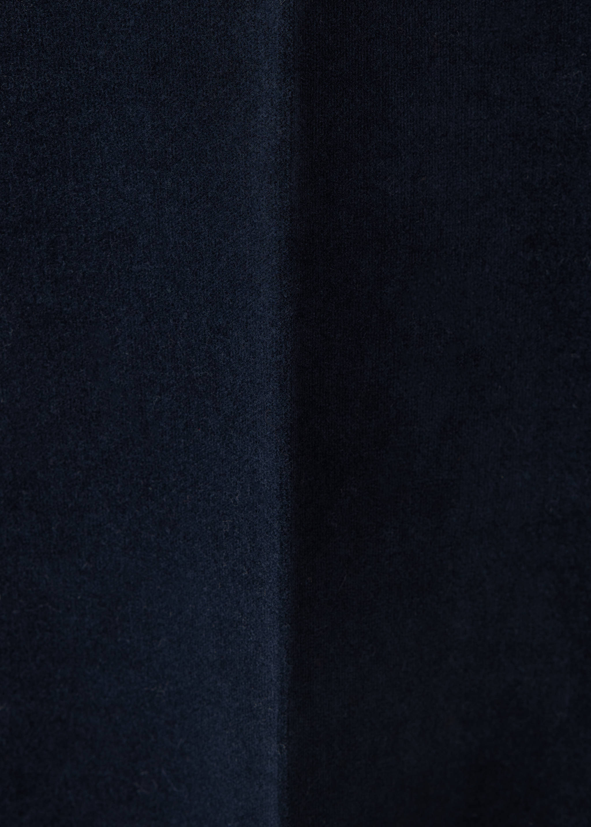 Close-up of dark blue denim fabric texture.