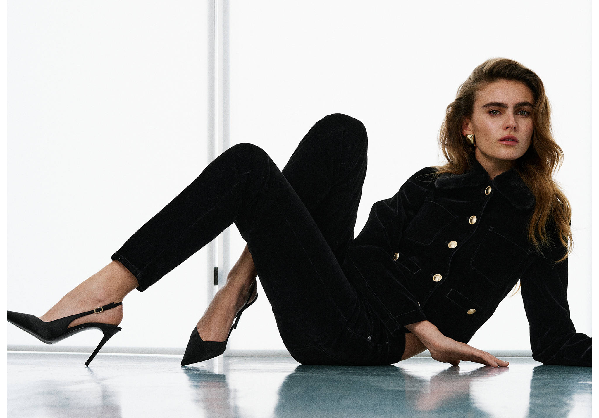 Black slim-fit denim trousers paired with a matching jacket.