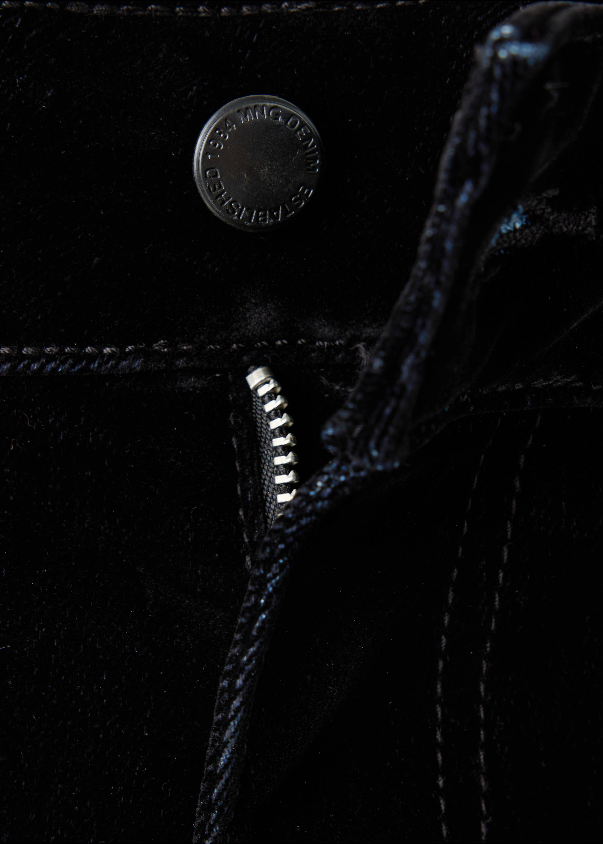 Close-up of black denim trousers focusing on the branded button and zip fly., Black. Ref: 37039119-00.
