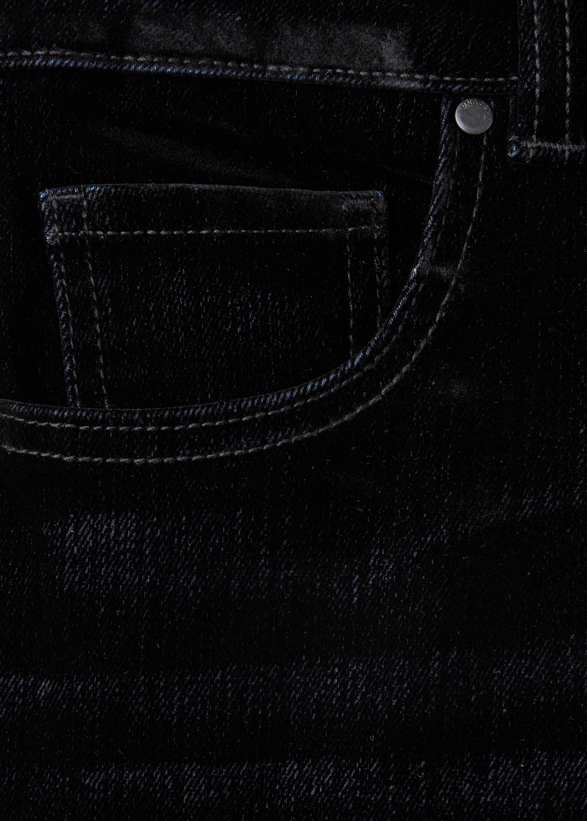 Close-up of dark blue denim trousers featuring a front coin pocket and contrast stitching.