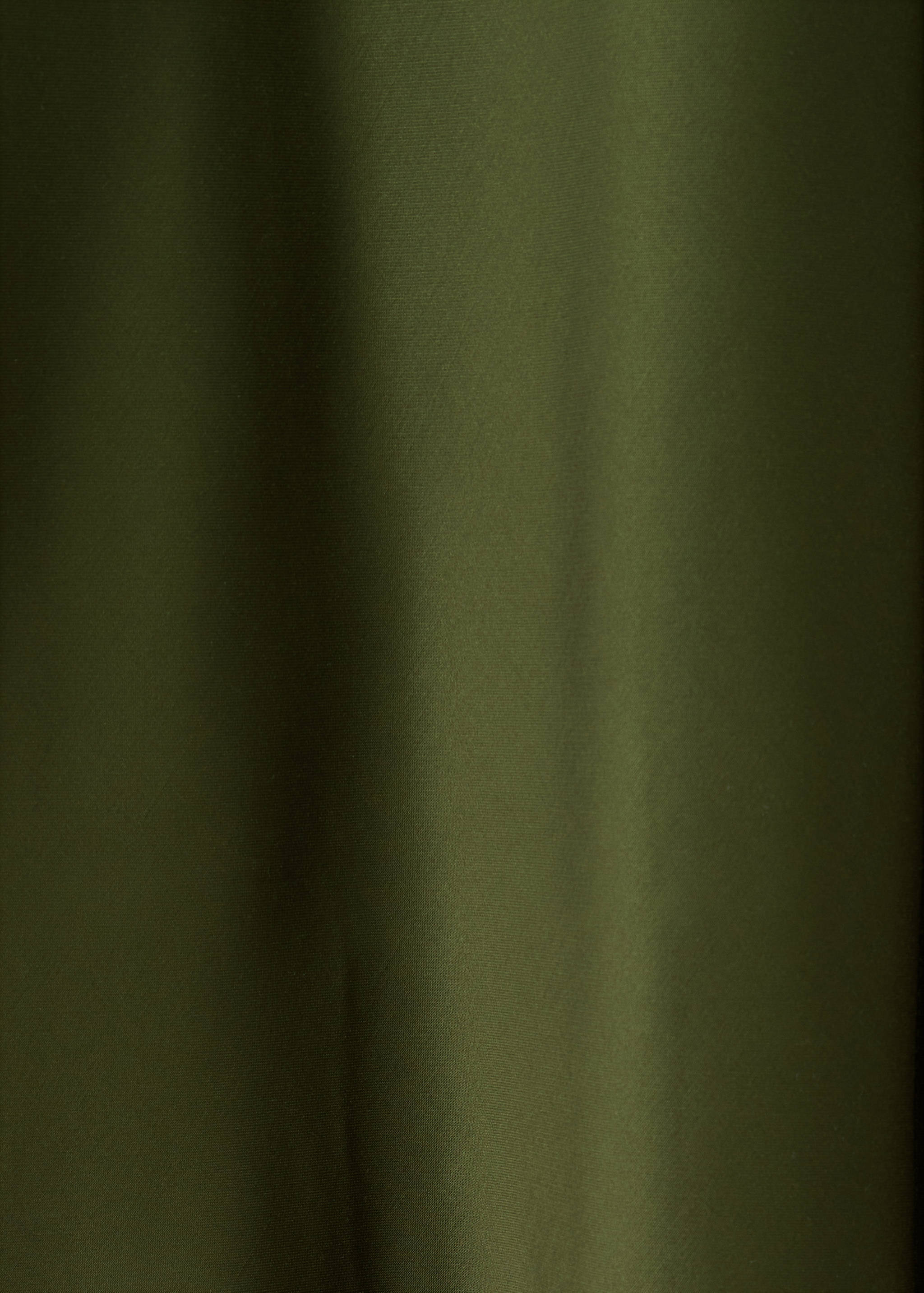 Detalle del tejido del vestido en verde caqui oscuro.