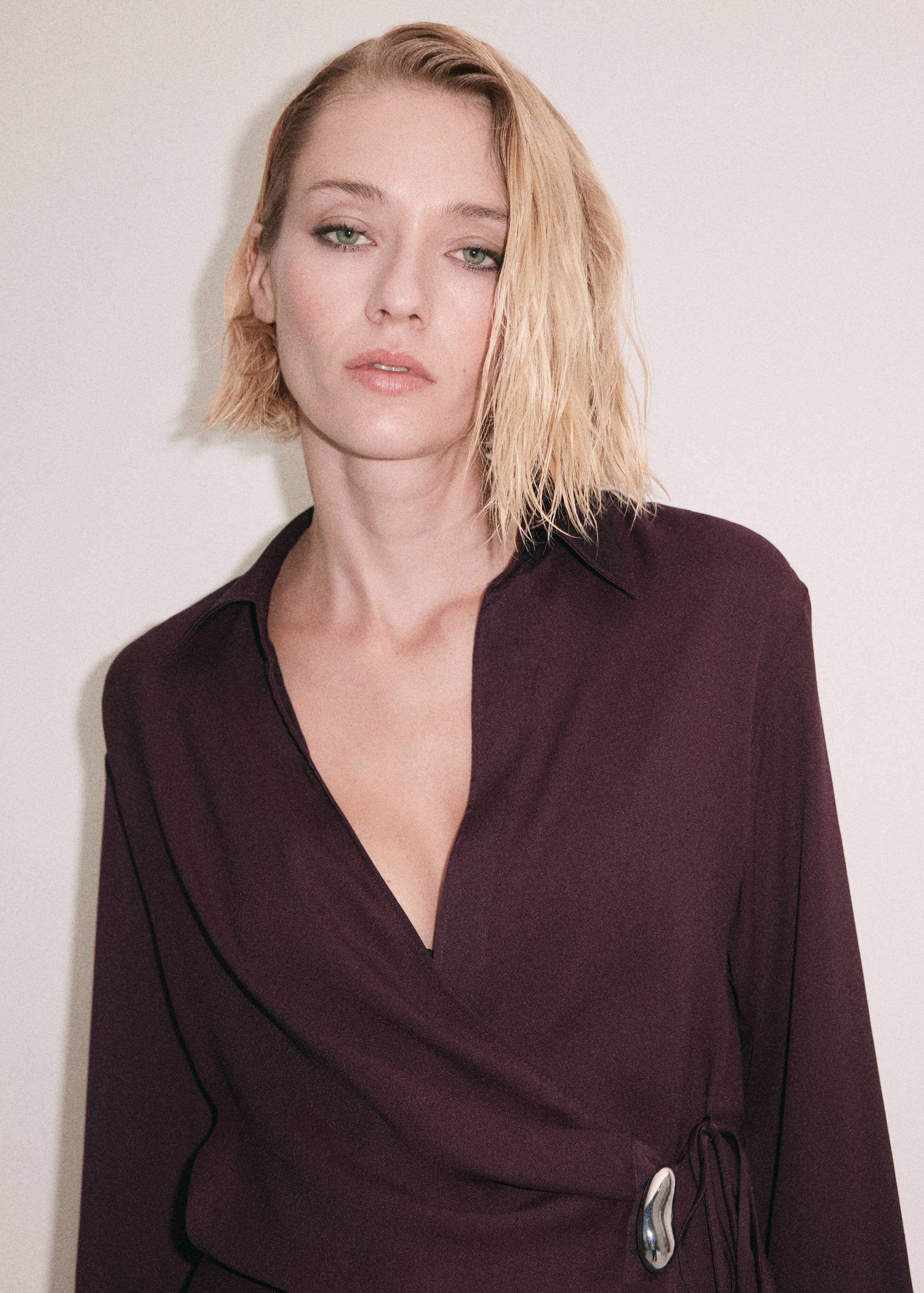 Burgundy wrap shirt with long sleeves, collar, and side metallic buckle detail