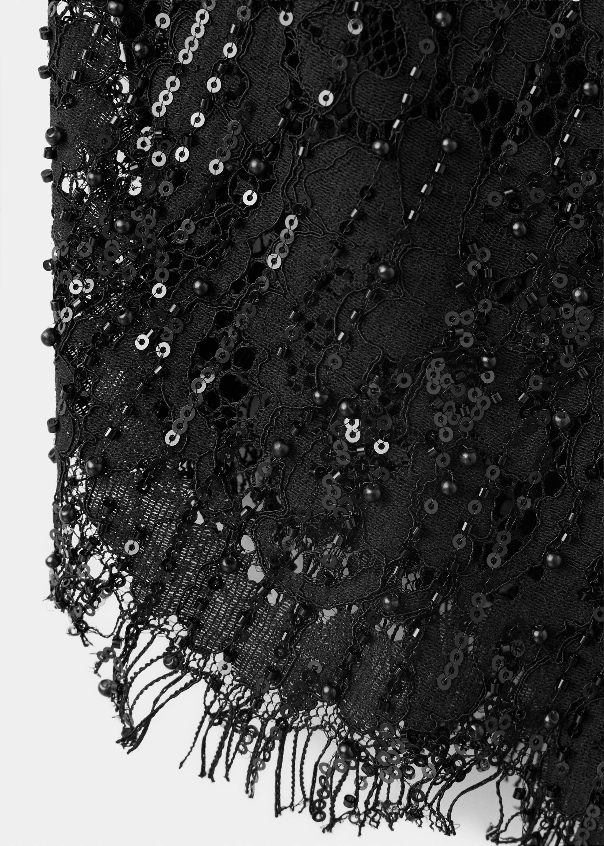 Close-up of the black skirt fabric, featuring sequin and bead embellishments on lace with a fringe trim., Black. Ref: 37039131-00.