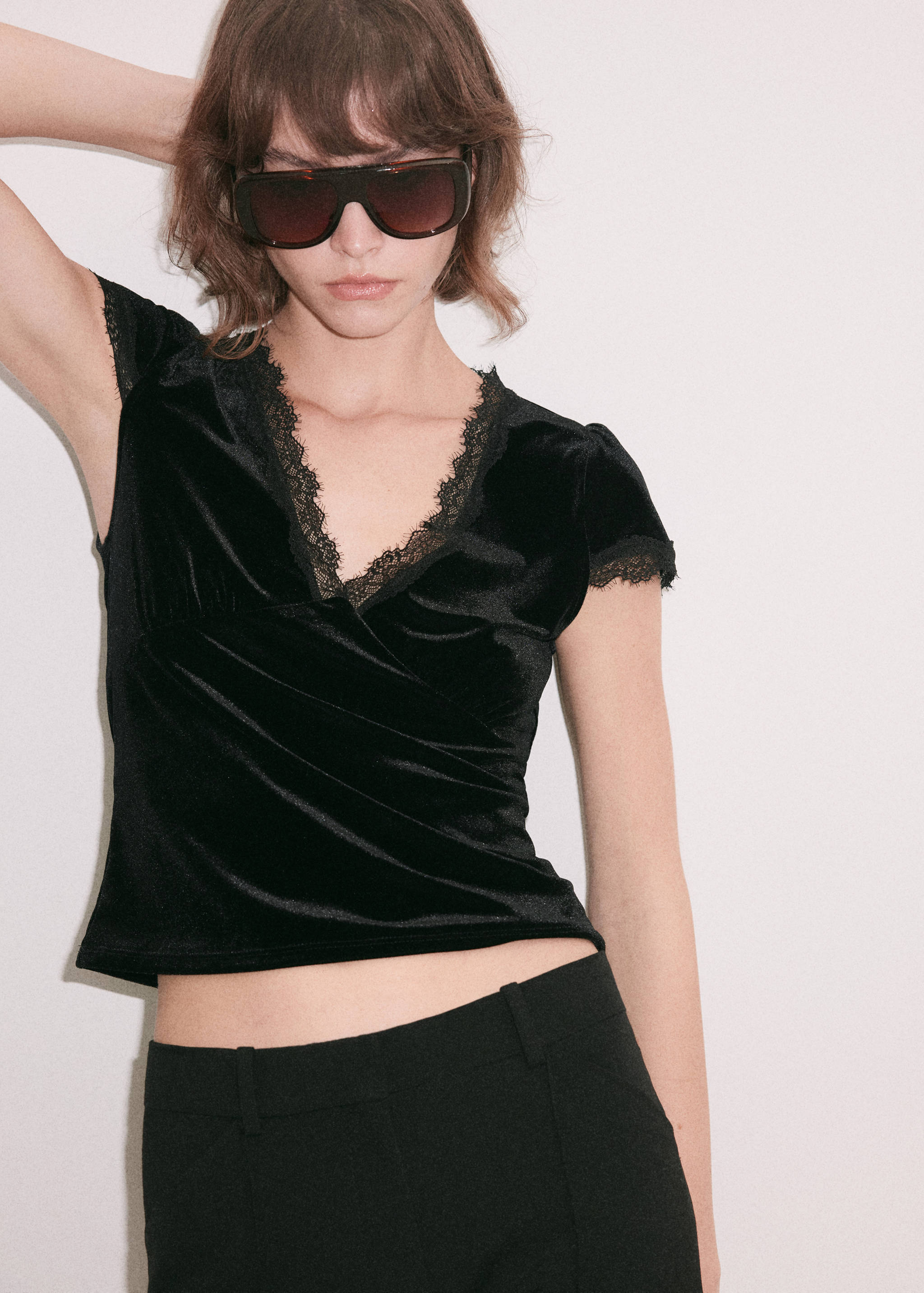 Black velvet V-neck top with short lace-trimmed sleeves.