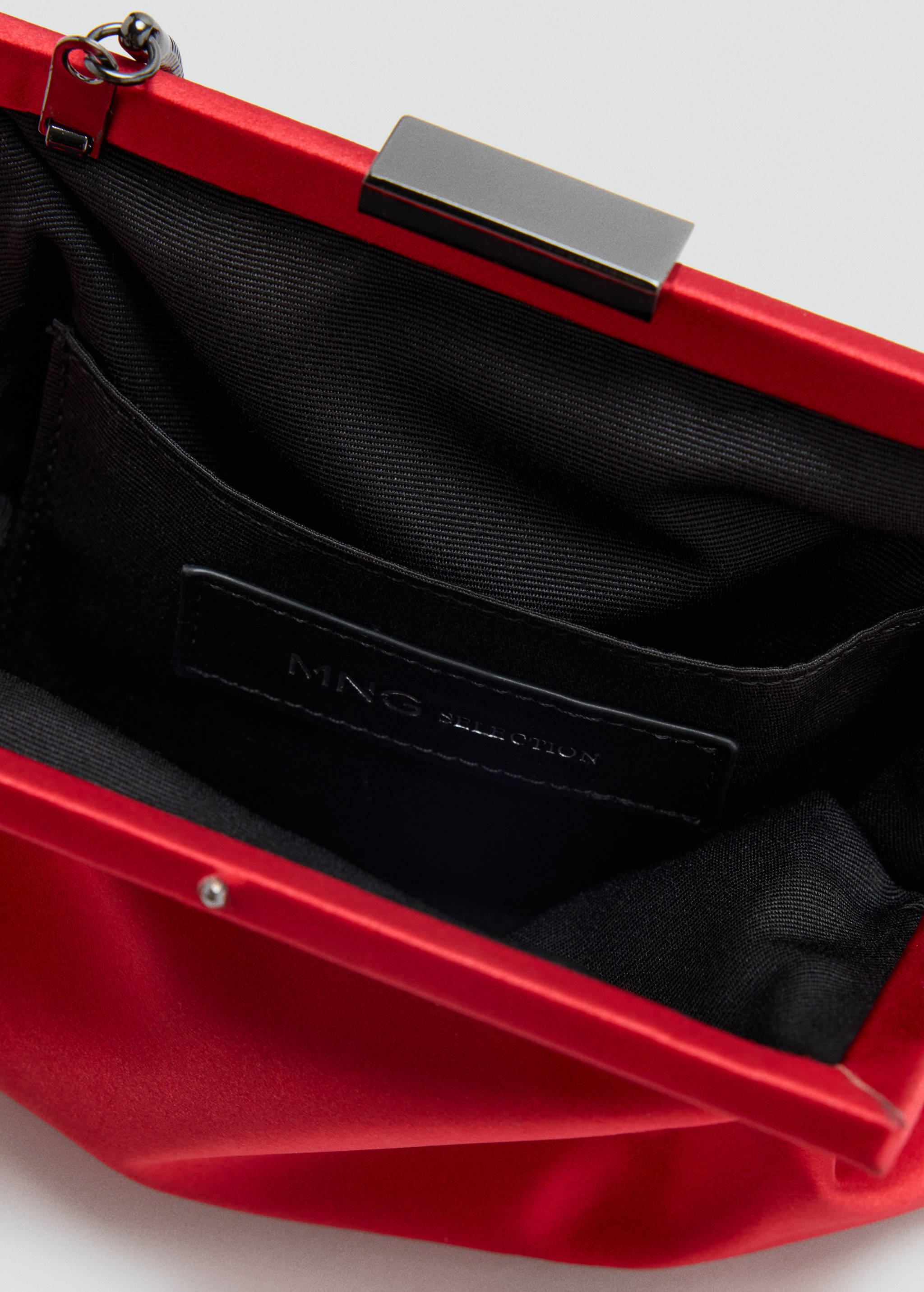 Close-up interior view of a red handbag showing the lining and logo label.