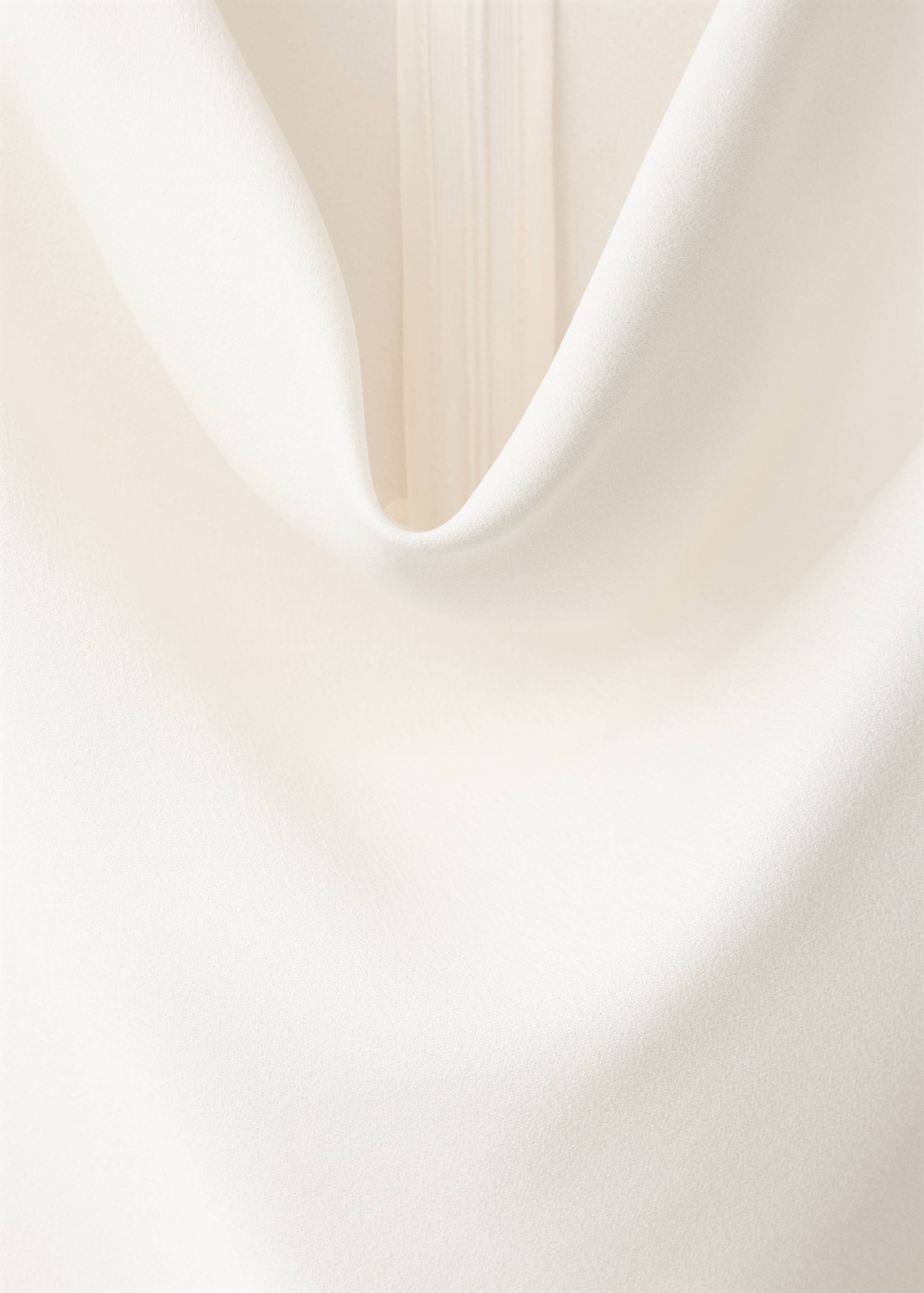 White top featuring a draped cowl neckline.
