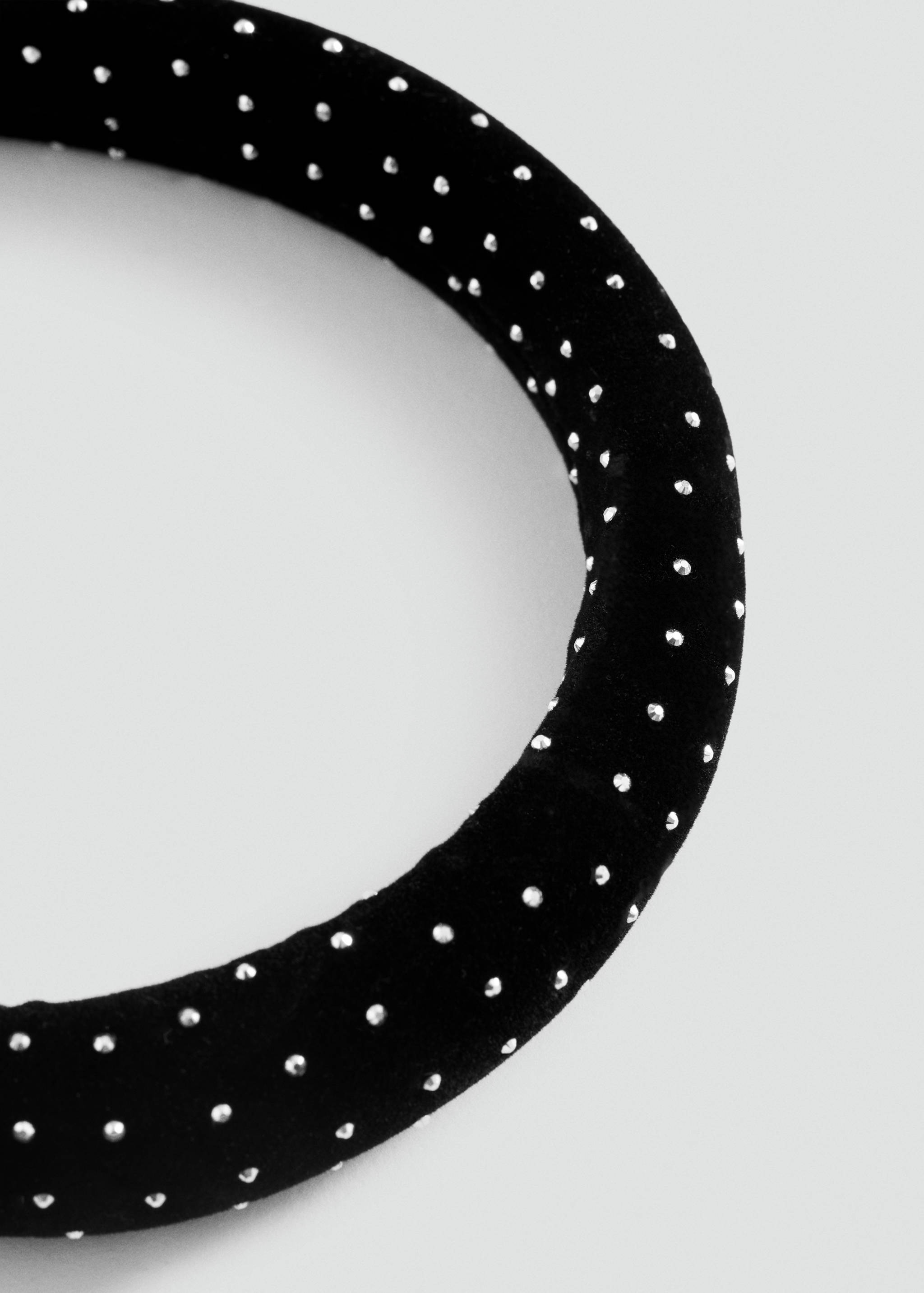 Close-up of a black headband with white polka dots.