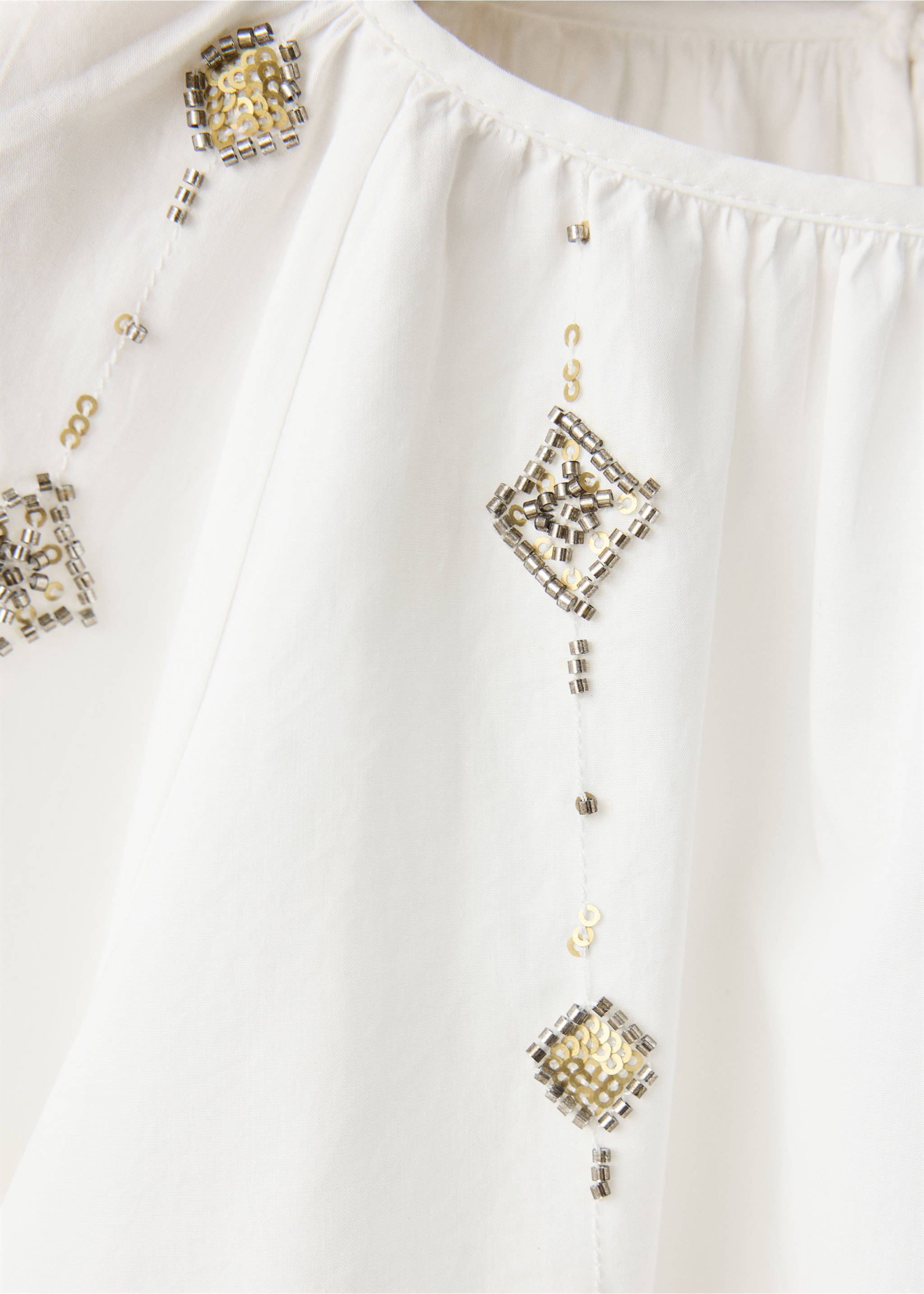 Close-up of a white blouse with beaded and sequinned diamond embroidery., White. Ref: 37039221-00.
