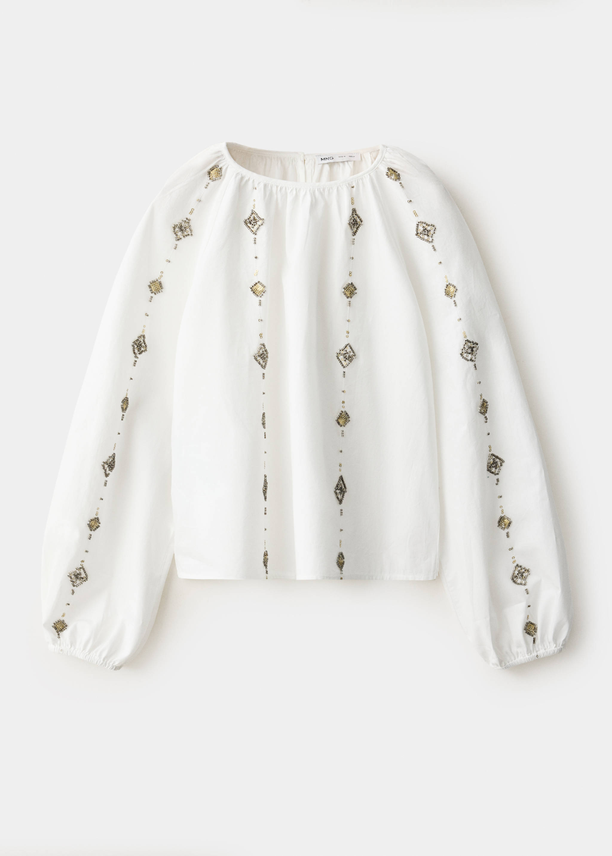White kids' blouse with a round neck and embroidered metallic details.