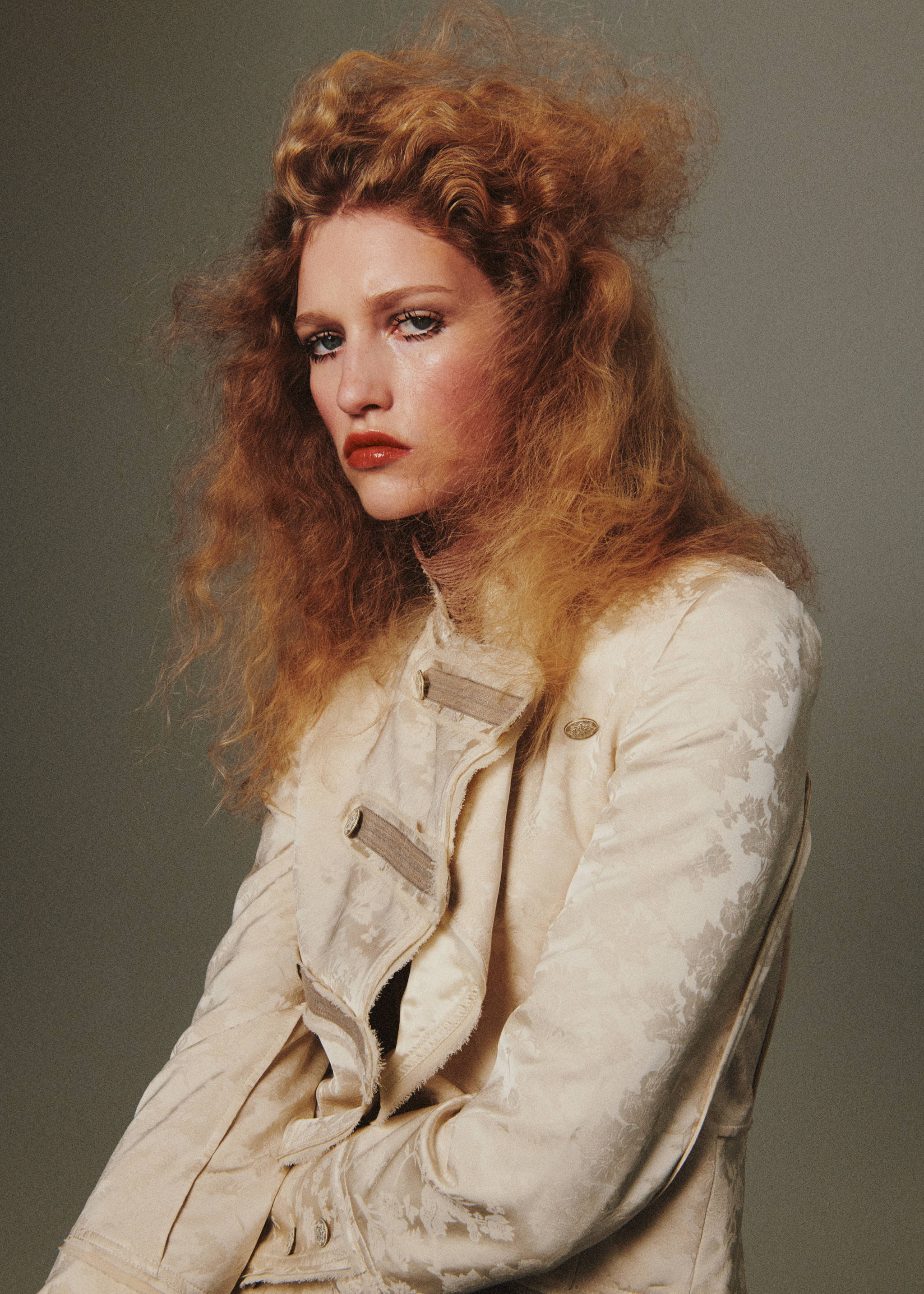 Cream jacquard jacket with high collar and toggle closures, shown in a model portrait.