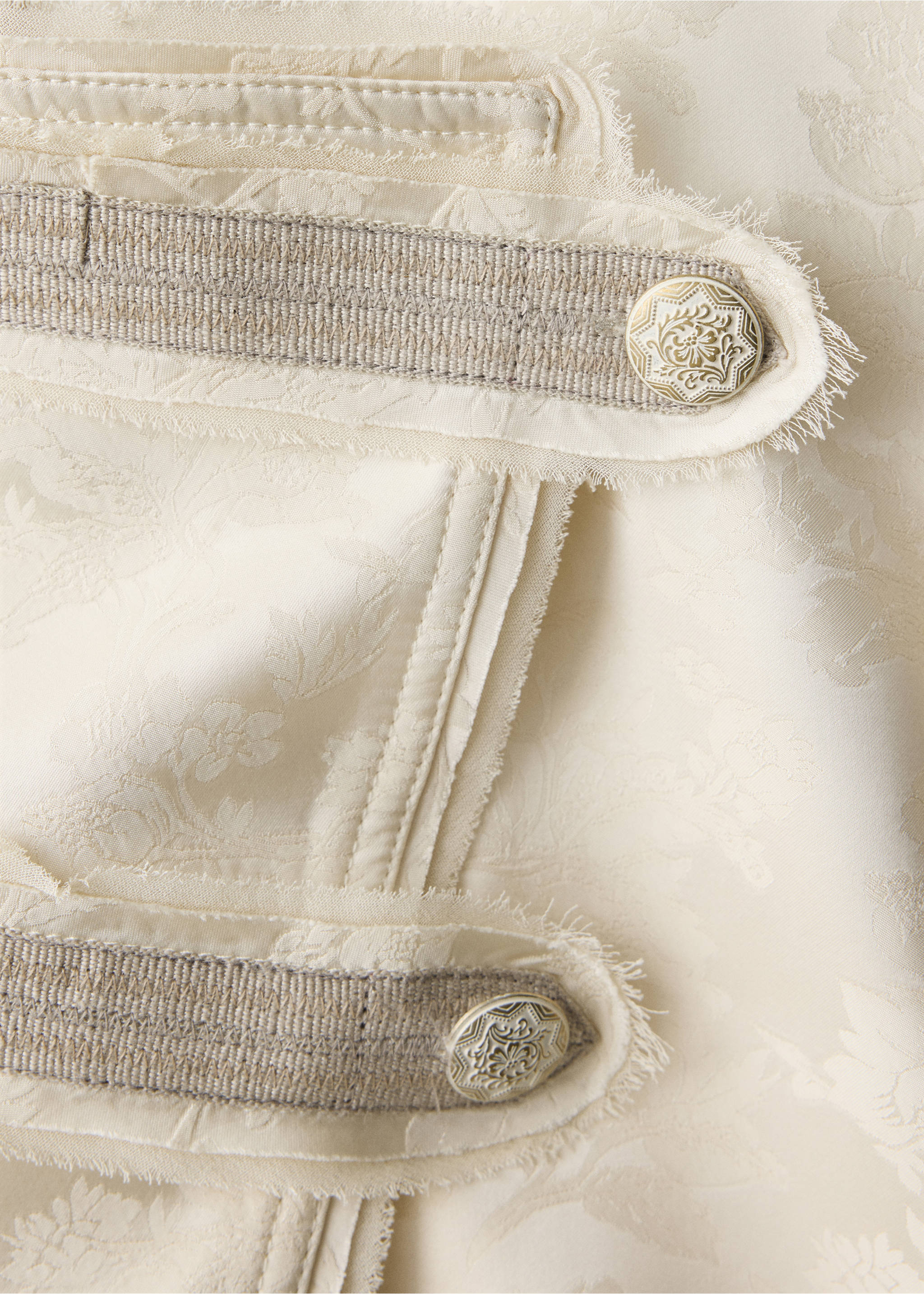 Close-up of a cream jacquard jacket with metallic buttons and trim., Ecru. Ref: 37039230-00.