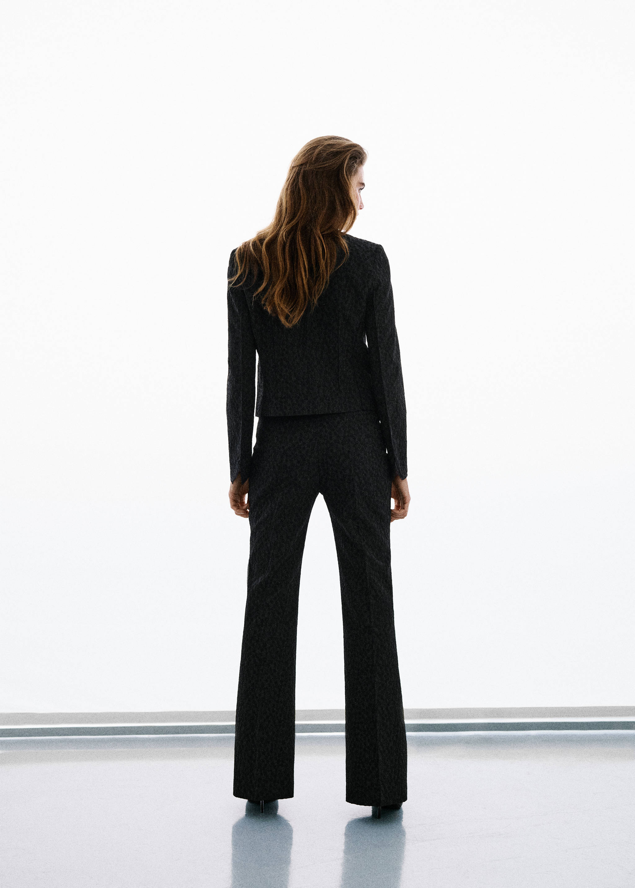 Dark patterned trousers, back view.
