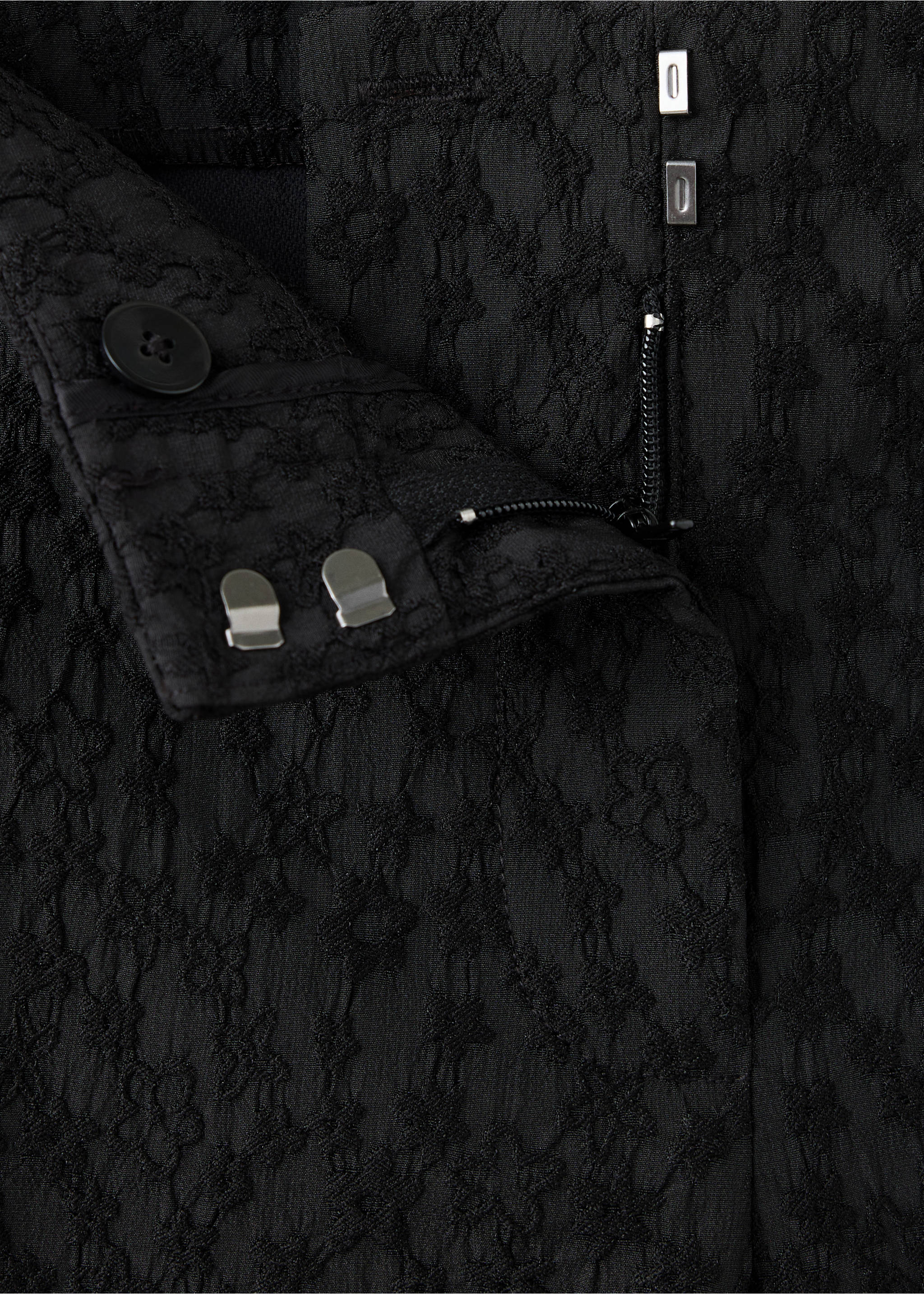 Close-up of black textured trousers showing the waistband and fastening details., Black. Ref: 37039404-00.