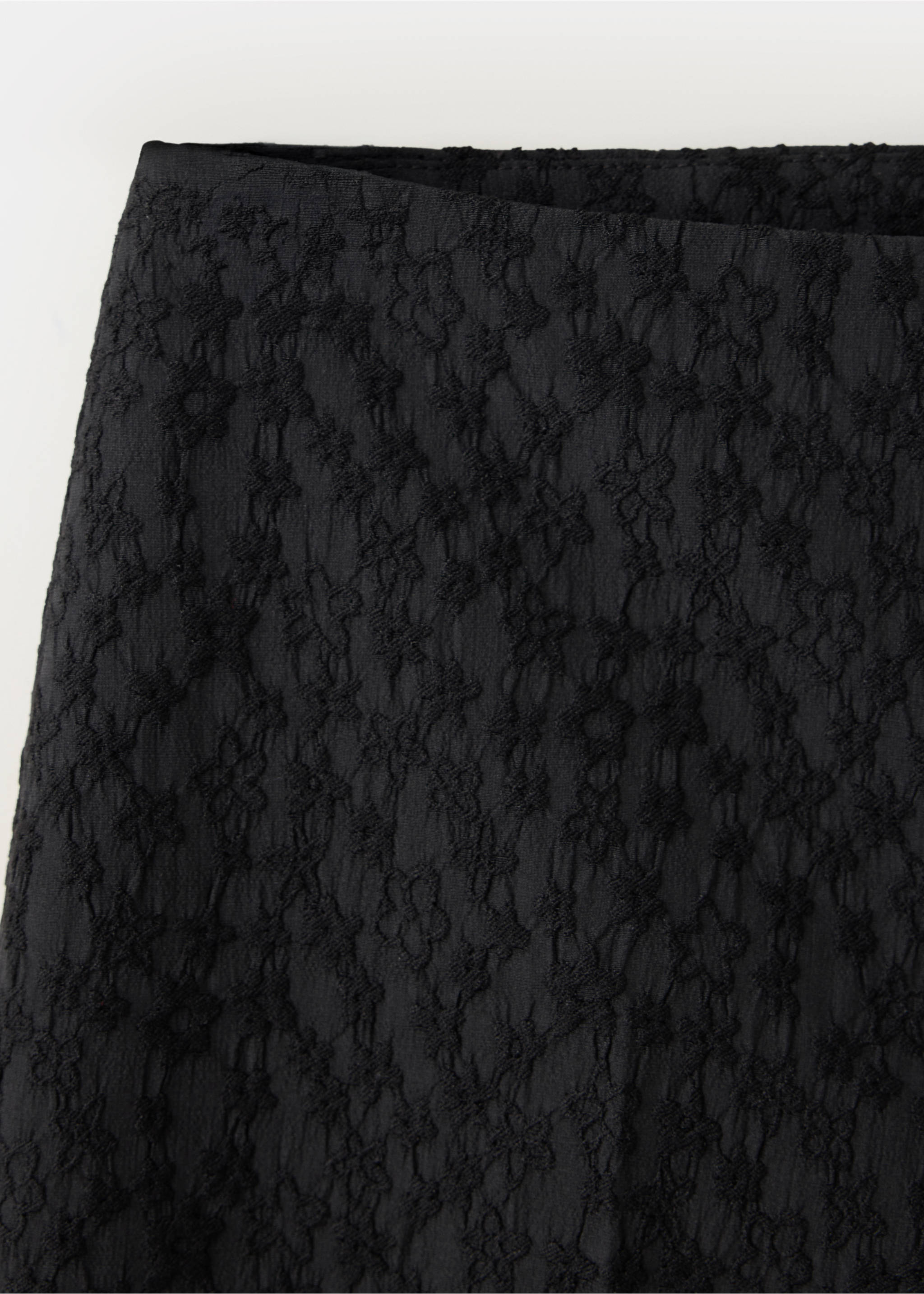 Close-up of black trousers featuring a textured floral lace fabric., Black. Ref: 37039404-00.