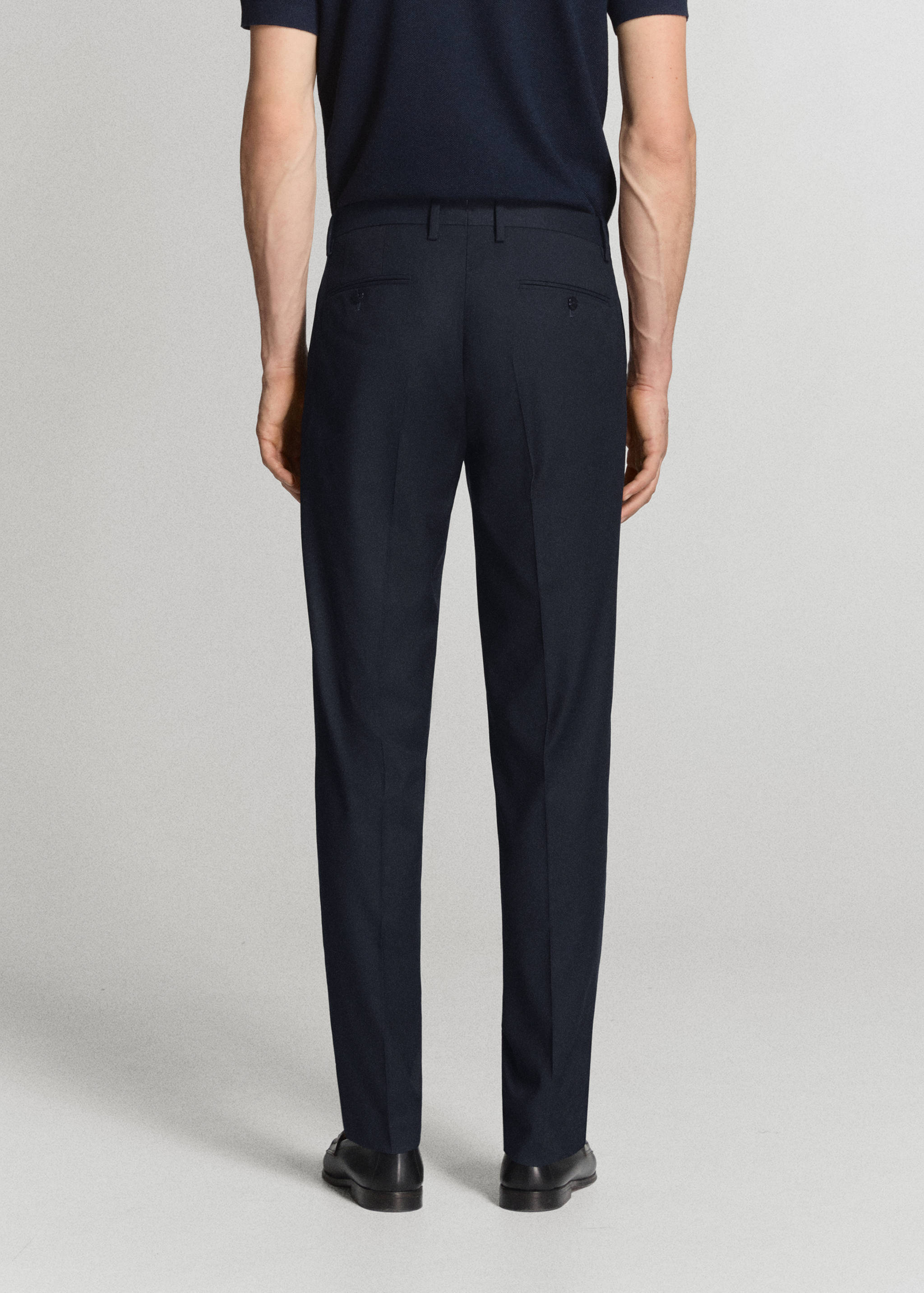 Navy blue slim-fit trousers from the back view.
