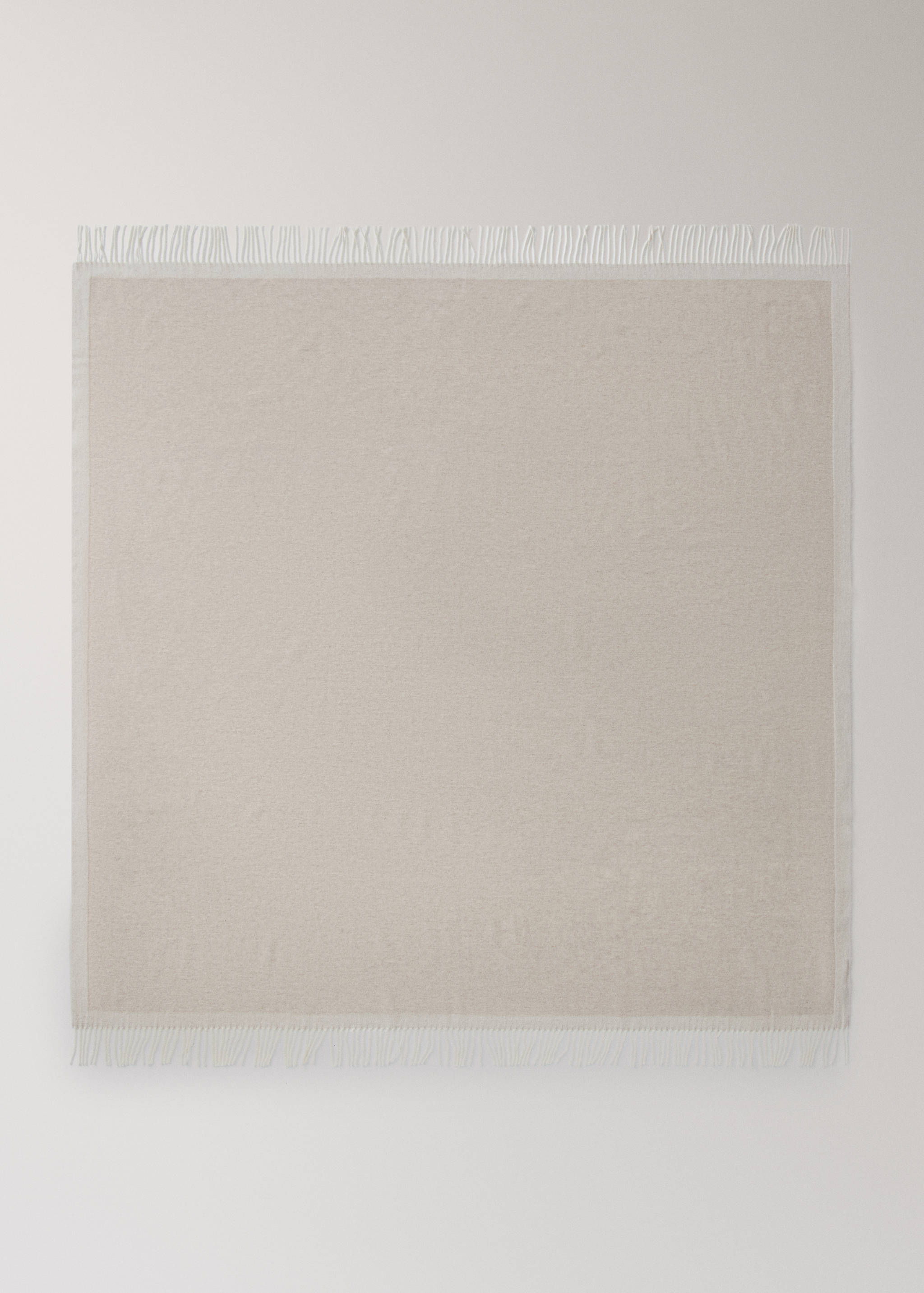Beige blanket with a tonal border and short fringed ends.