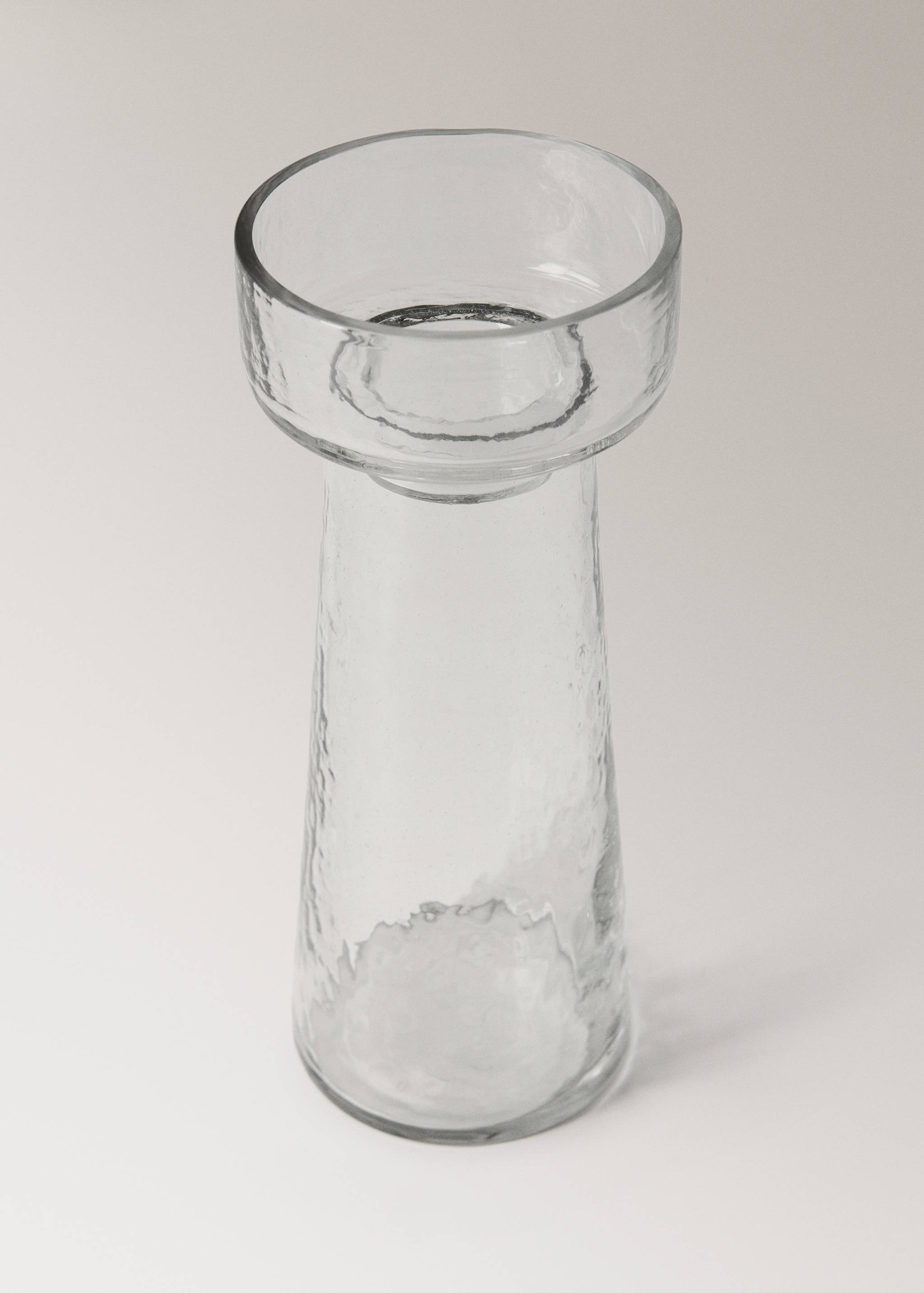 Clear glass candle holder with a flared top and textured body.