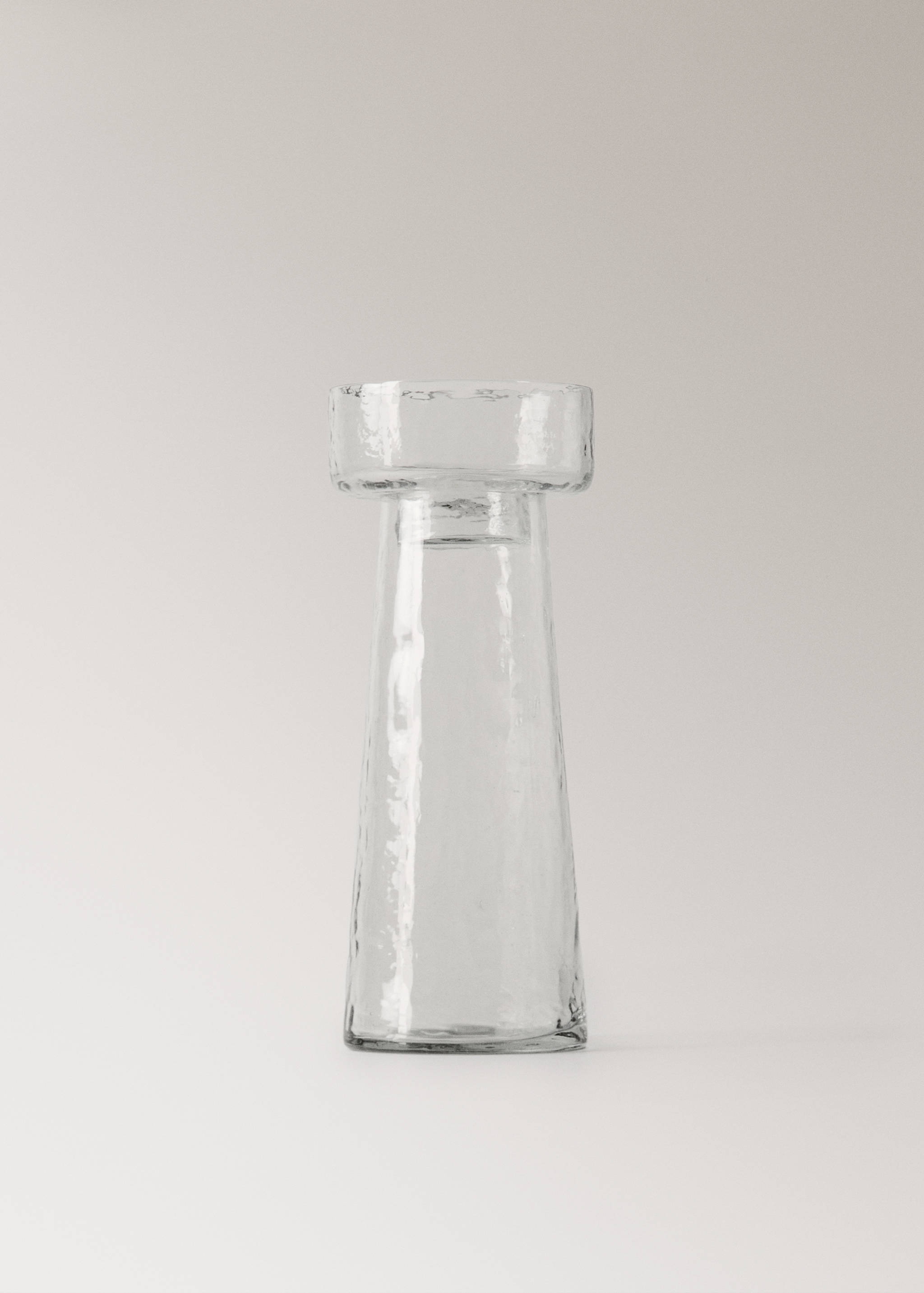 Transparent glass candle holder with a flared cylindrical body.