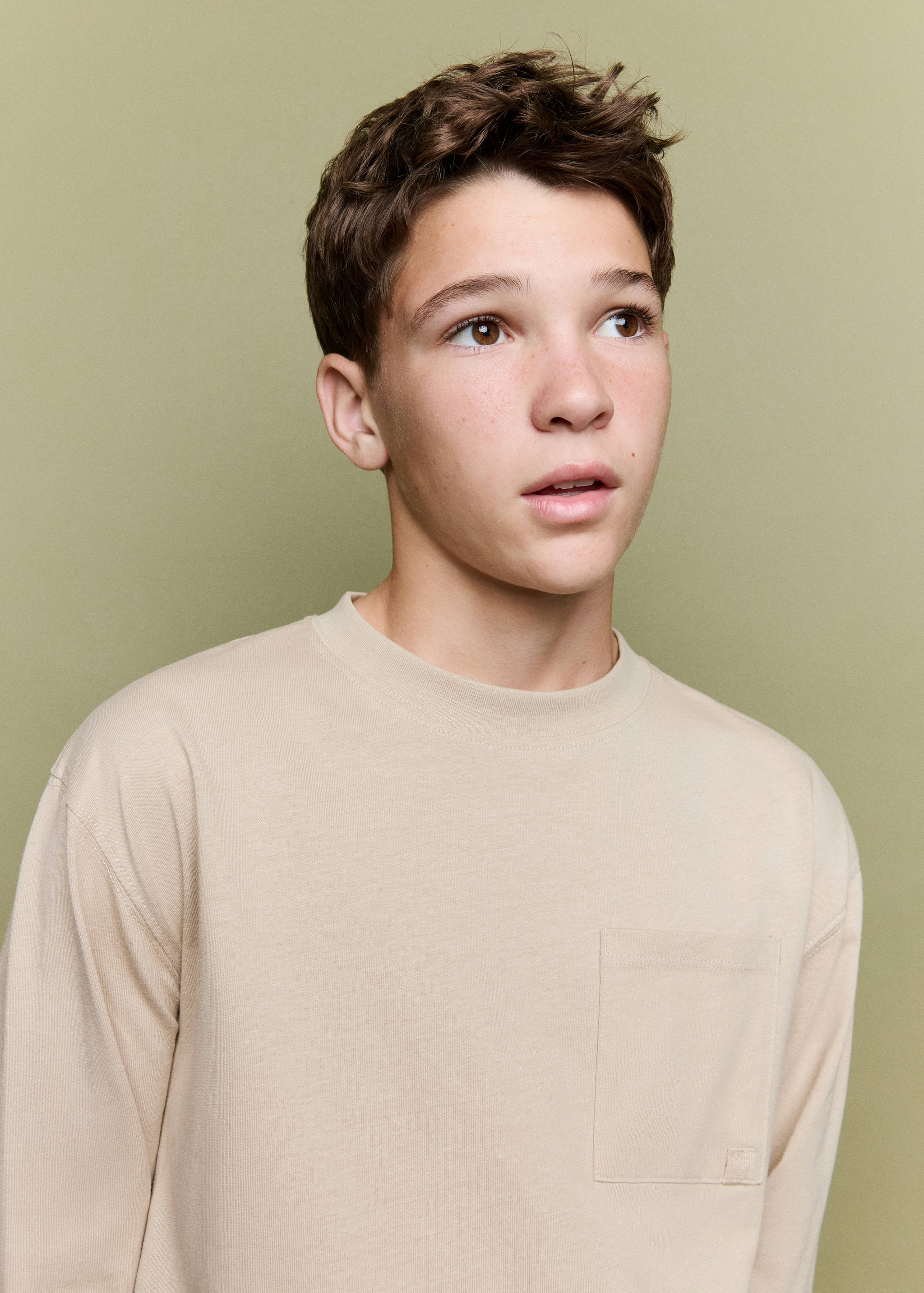 Beige long-sleeved t-shirt with crew neck and chest pocket.