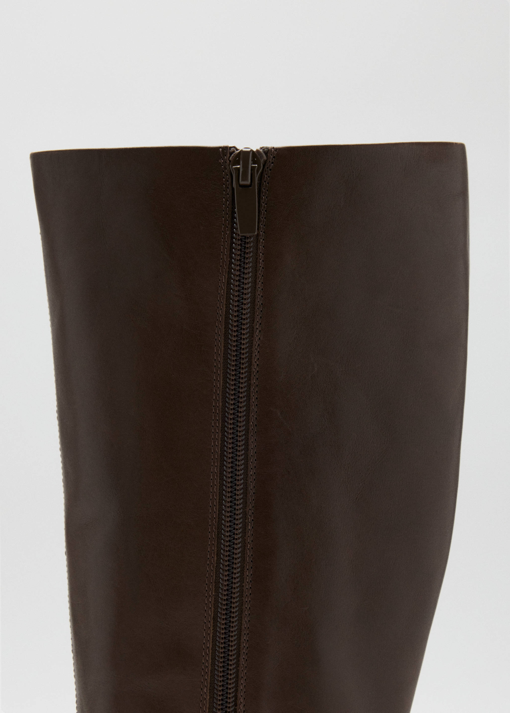 Close-up of the back zipper detail on a dark brown boot.