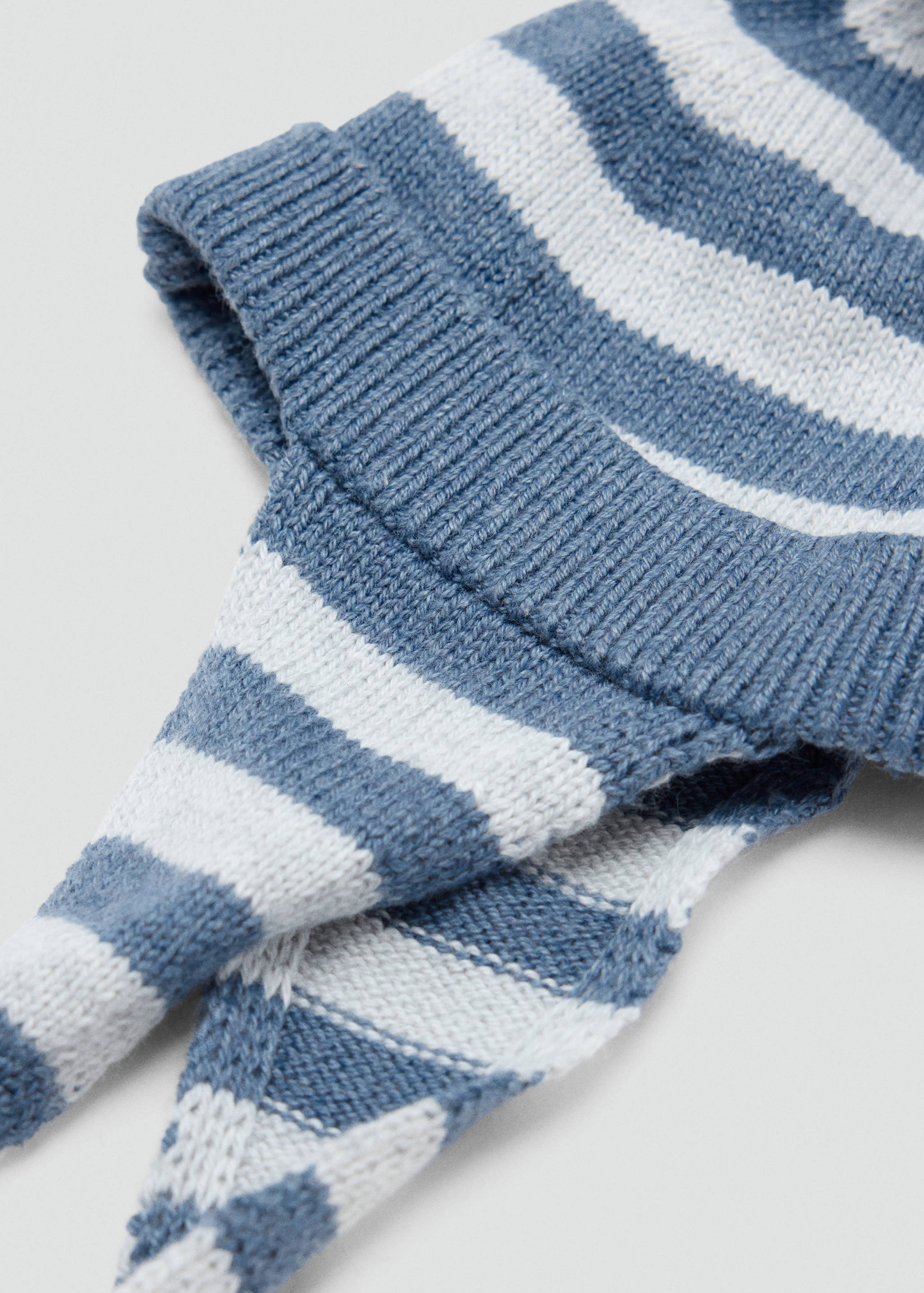 Gorro de punto de rayas azules y blancas con vuelta de canalé y orejeras.