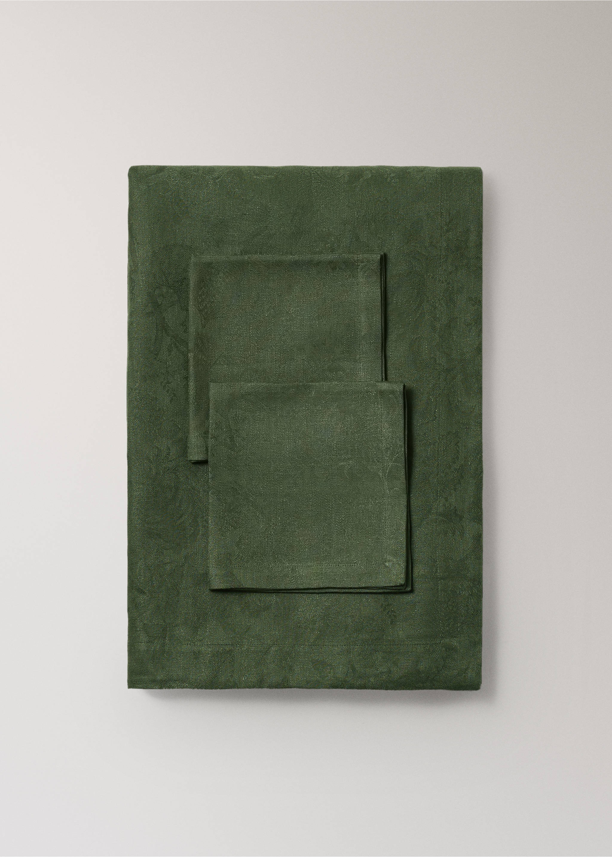 Dark green tablecloth with a subtle botanical pattern and matching folded napkins., Green. Ref: 37046731-00.