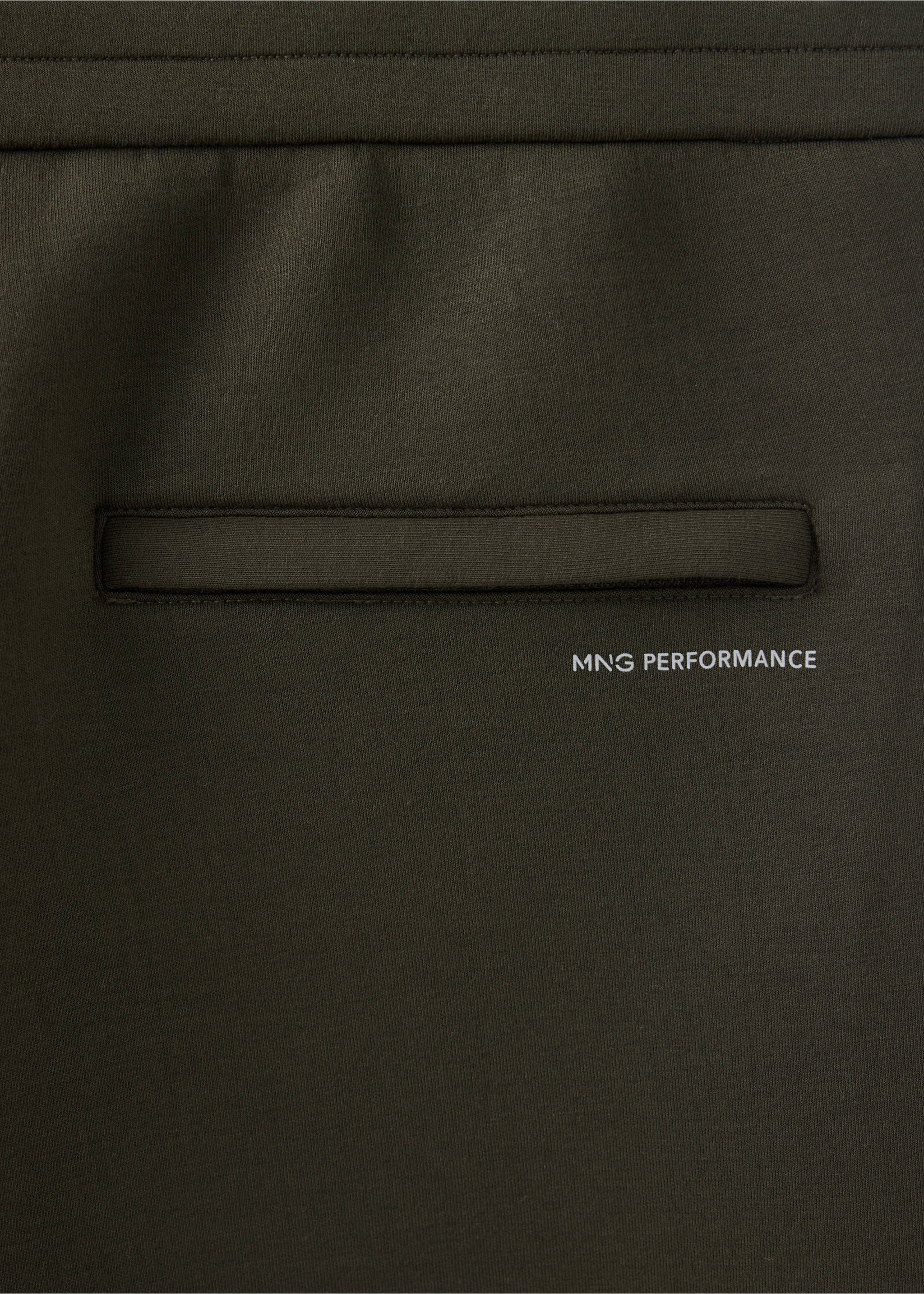 Detalle de tejido de joggers en verde oscuro con un bolsillo y el texto MNG PERFORMANCE., Khaki. Ref: 37046738-00.