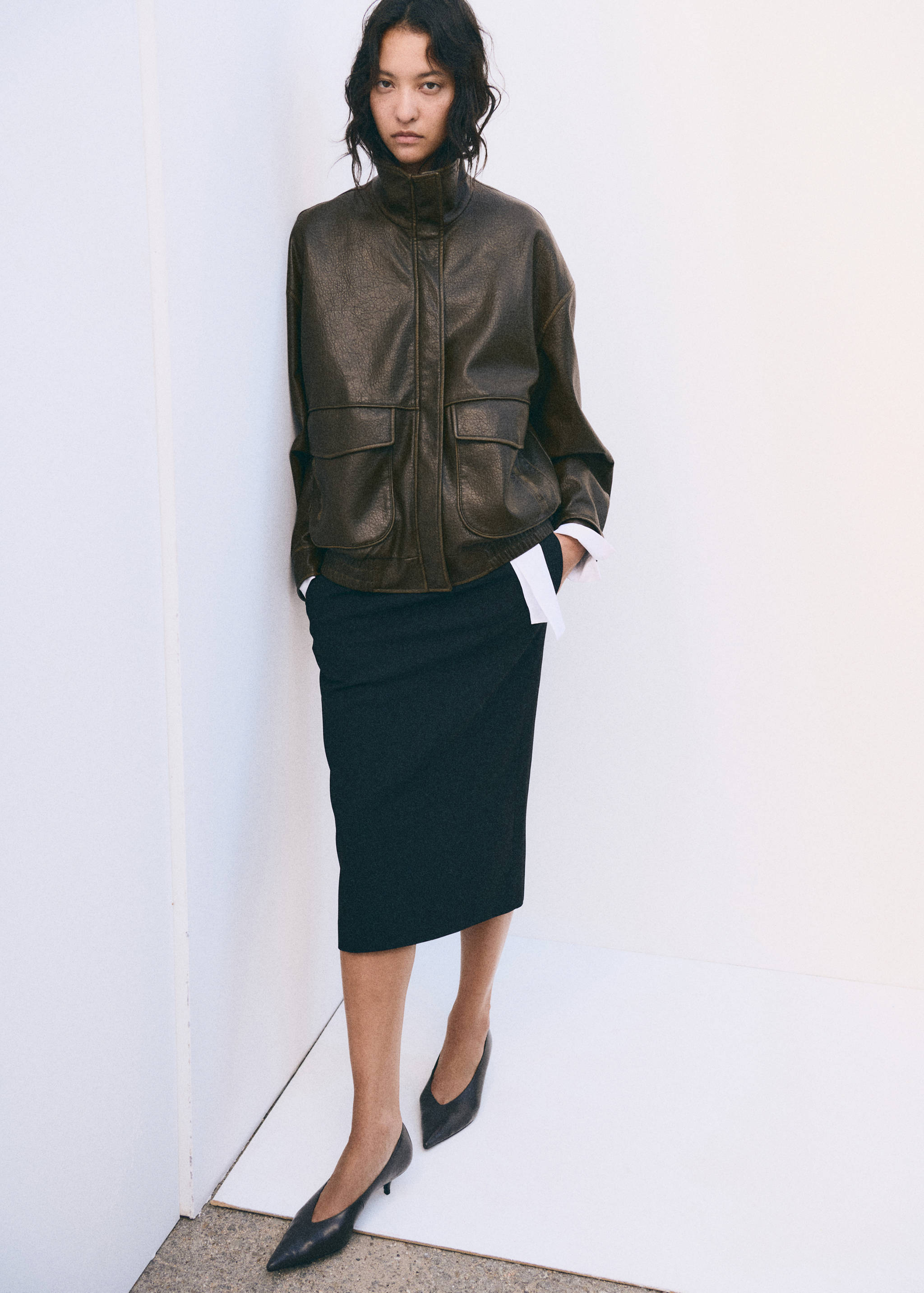 Dark brown oversized jacket with high collar and flap pockets.