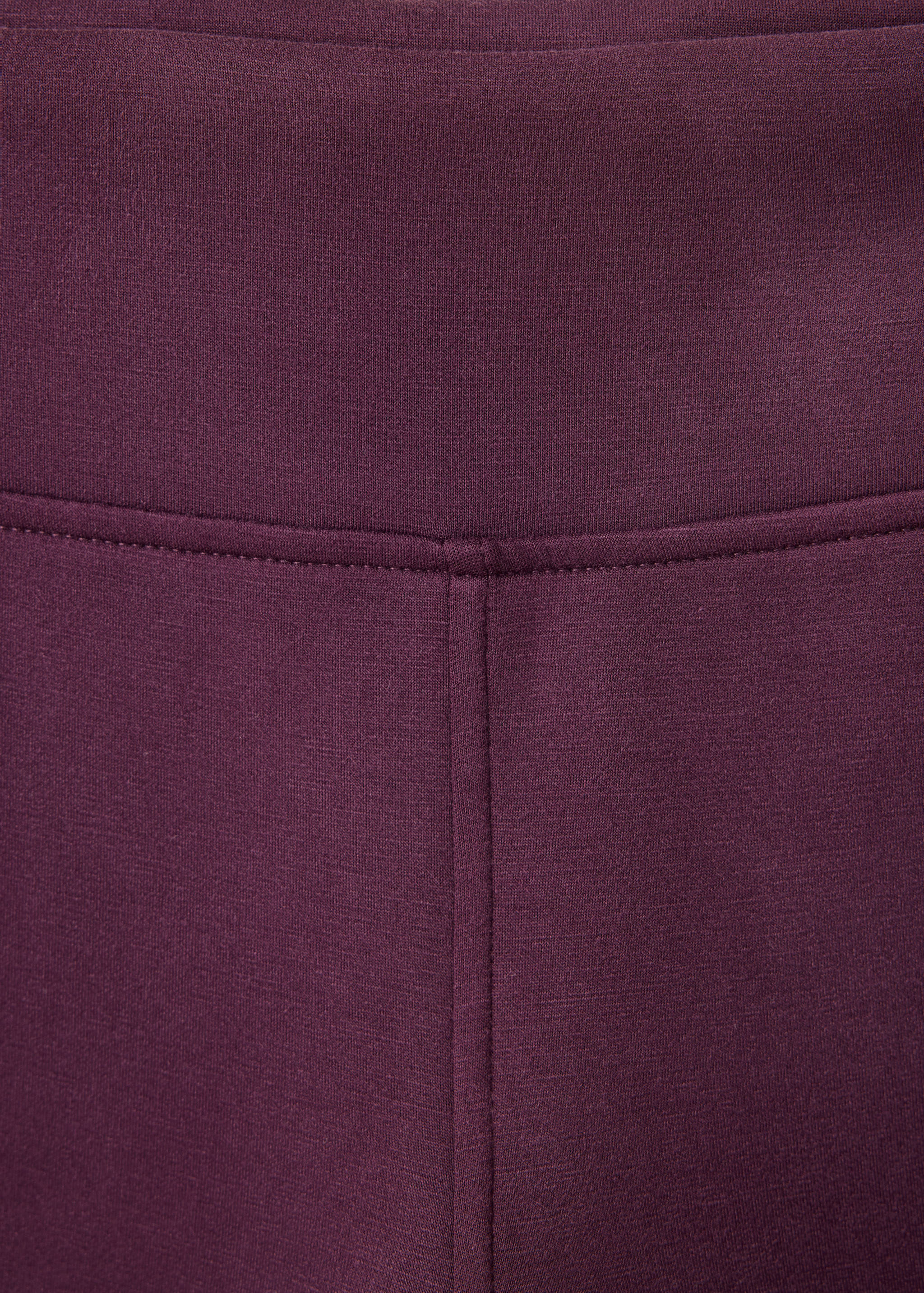 Plum leggings detail showing the waistband and stitched seams.