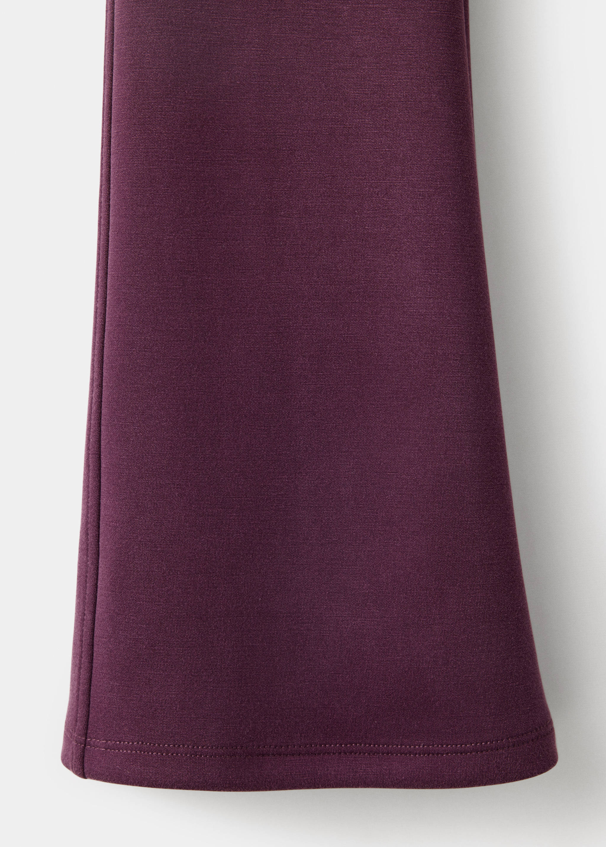 Close-up of the dark plum purple leggings fabric and lower leg.