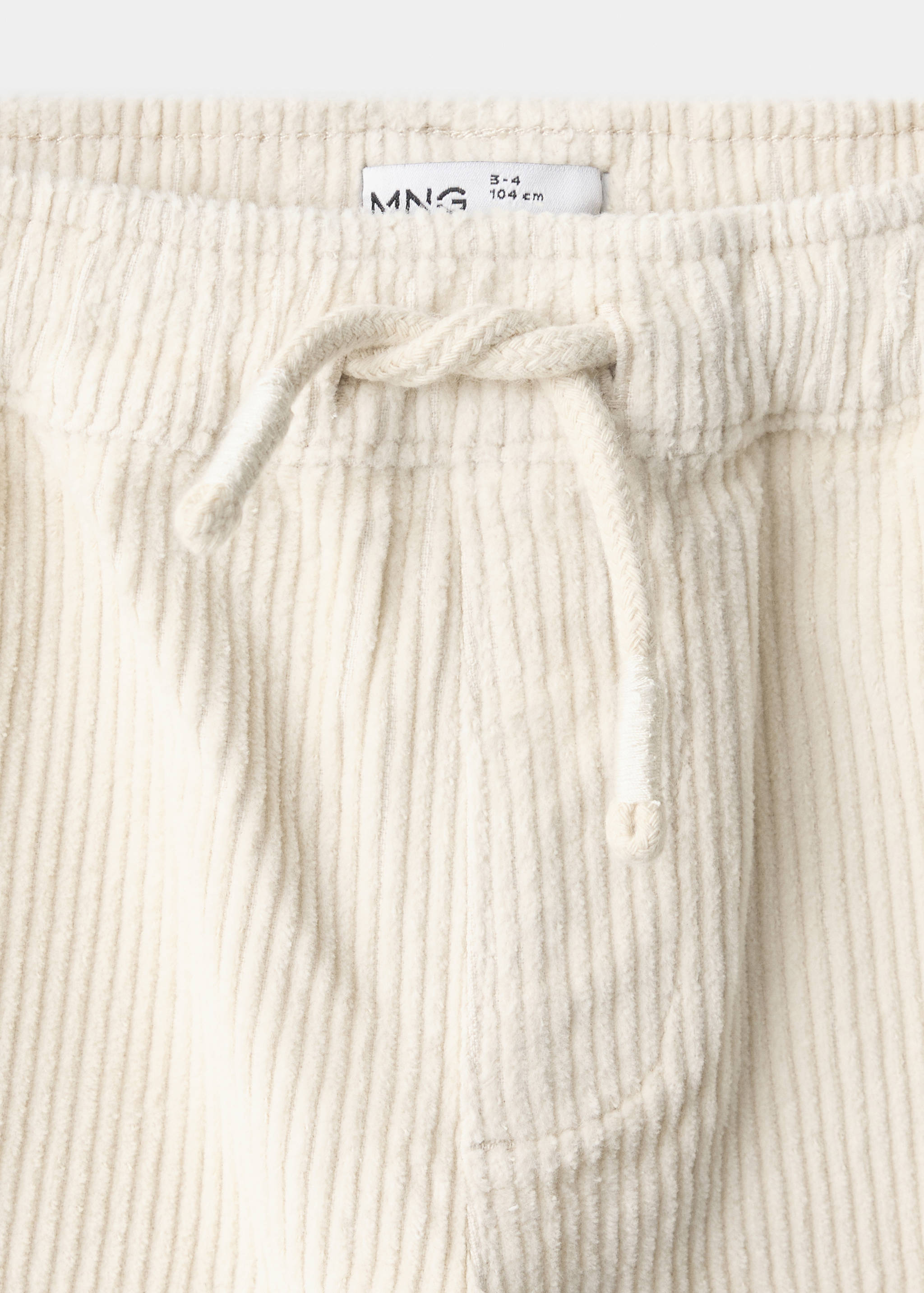 Close-up of off-white corduroy trousers waistband with a drawstring.