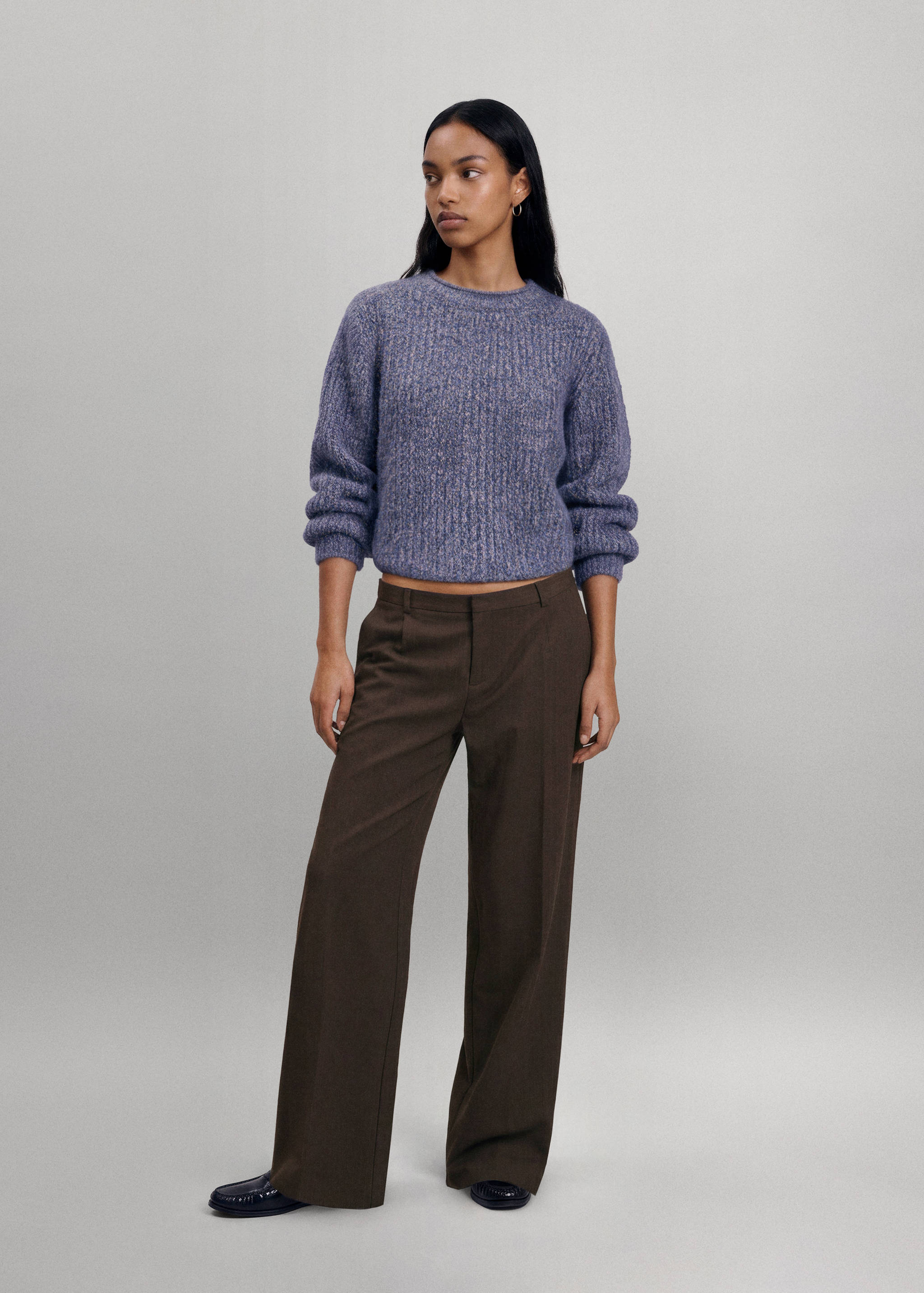 Brown trousers with a straight-leg silhouette, worn with a textured purple-blue sweater.