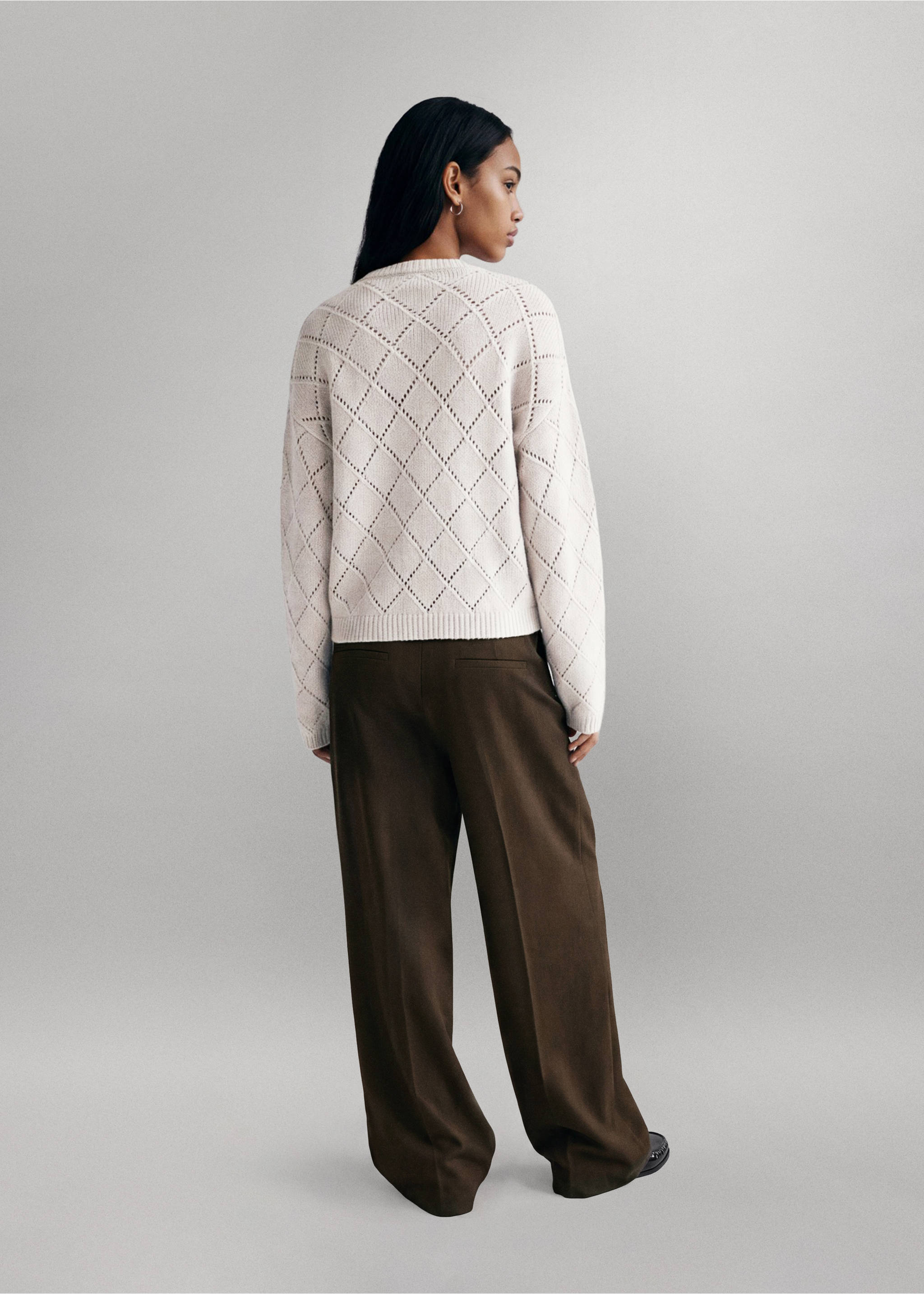 Off-white knitted diamond-pattern jersey from the back, worn with dark trousers, Sand. Ref: 37047137-00.
