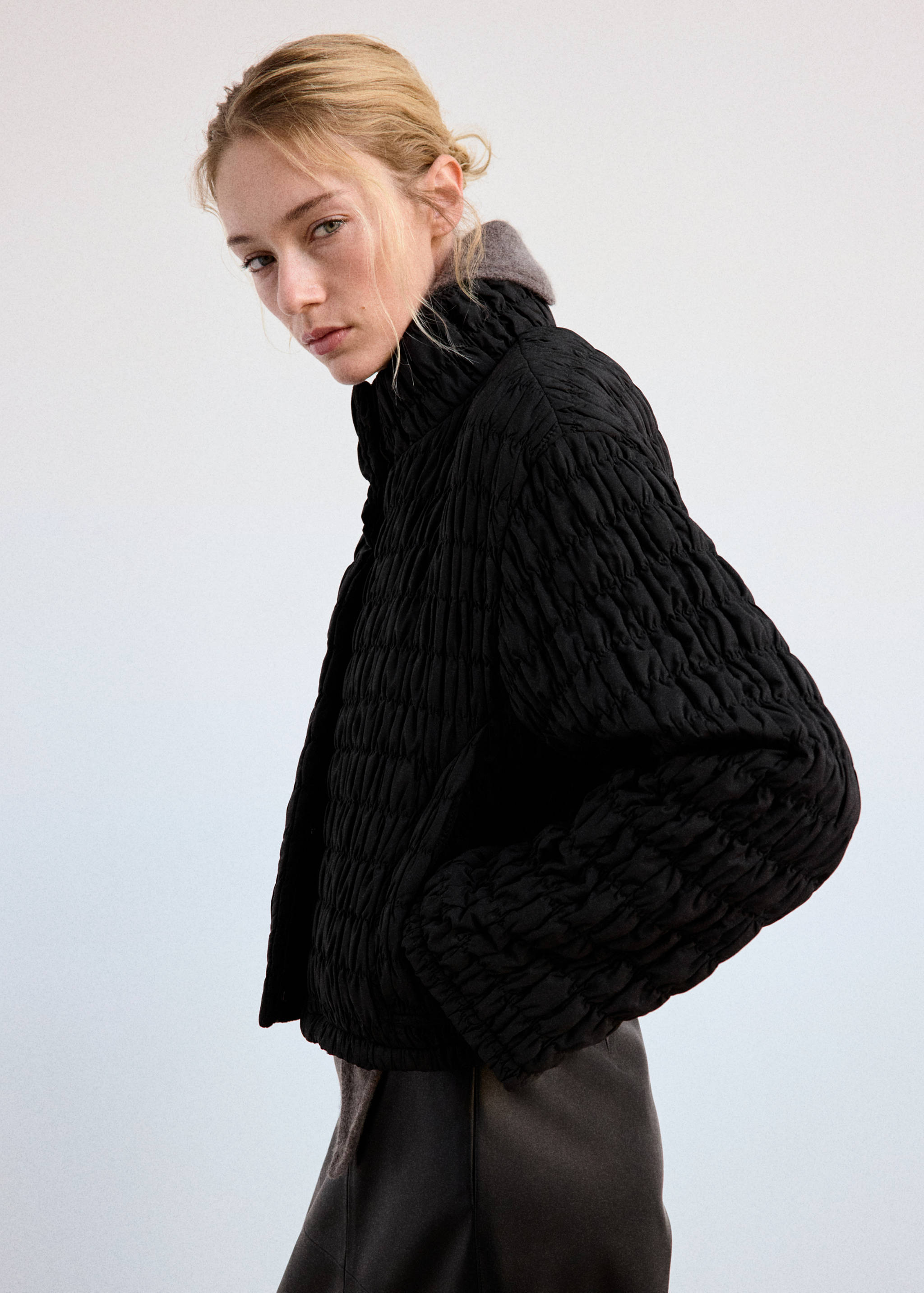 Black quilted anorak with a crinkled texture and high funnel neck
