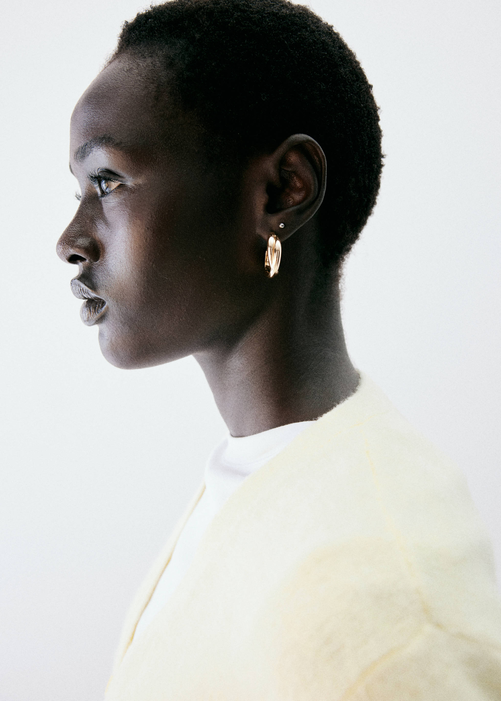Pale yellow cardigan, side view with model detail