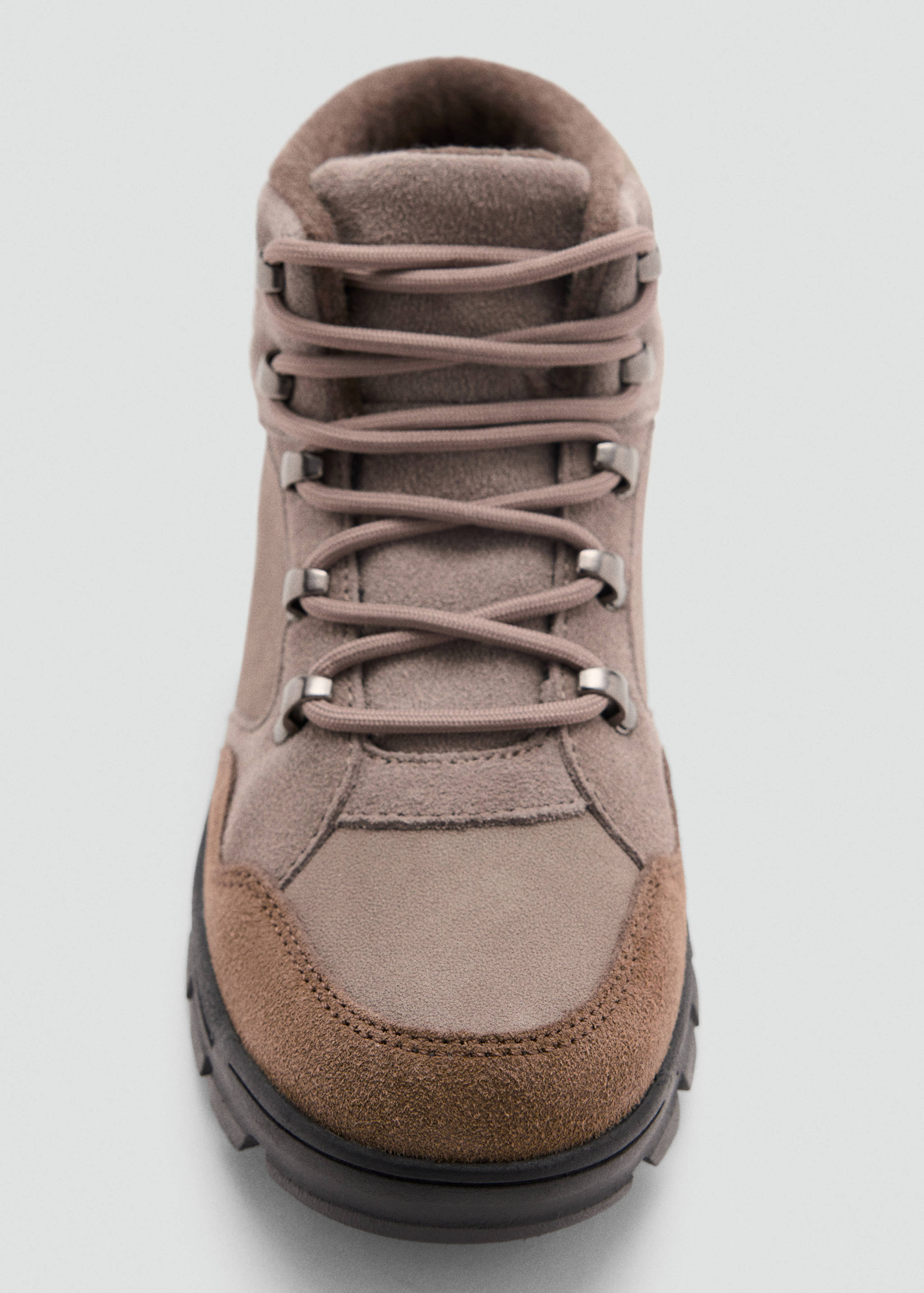 Close-up of taupe children's ankle boot with laces and metal eyelets.