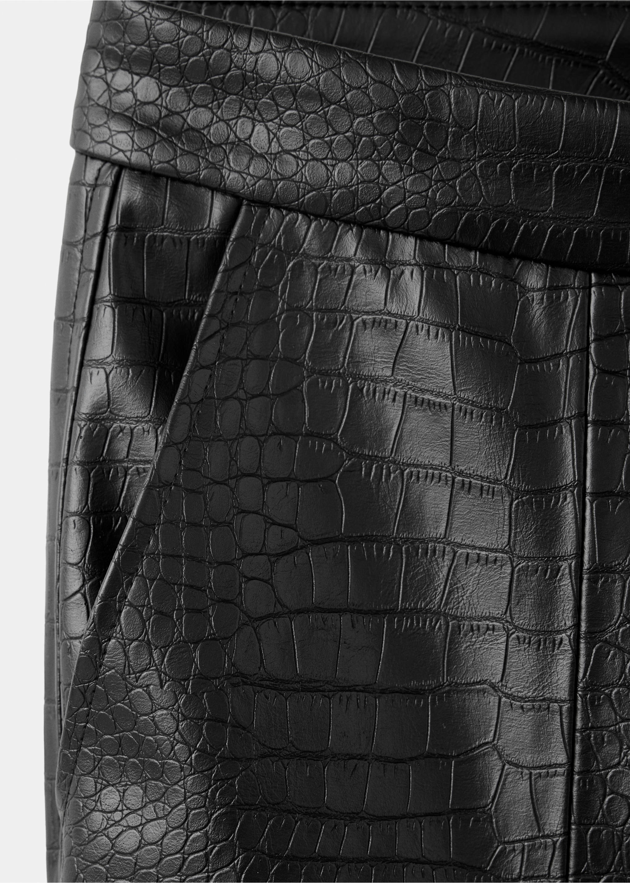Close-up of black trousers with an embossed crocodile texture., Black. Ref: 37047789-00.