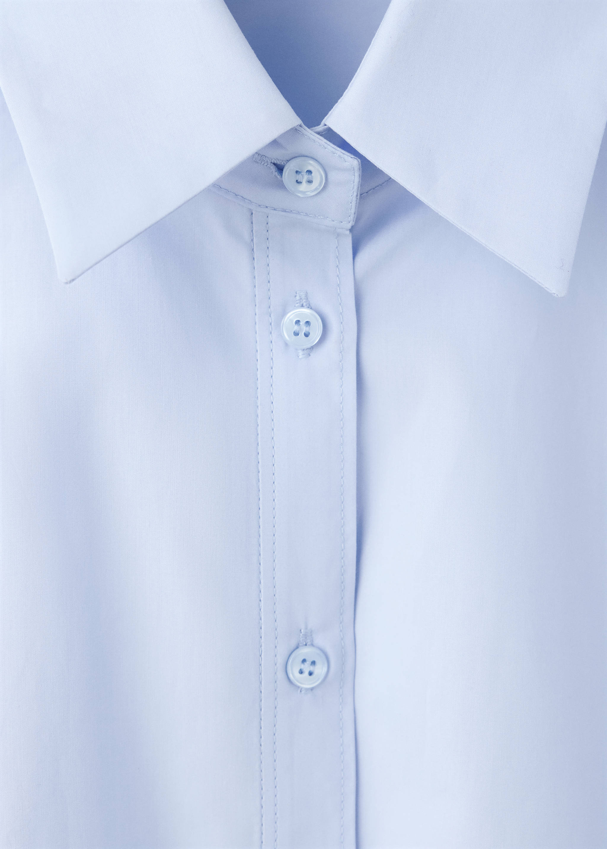 Close-up of a light blue shirt collar and button placket.