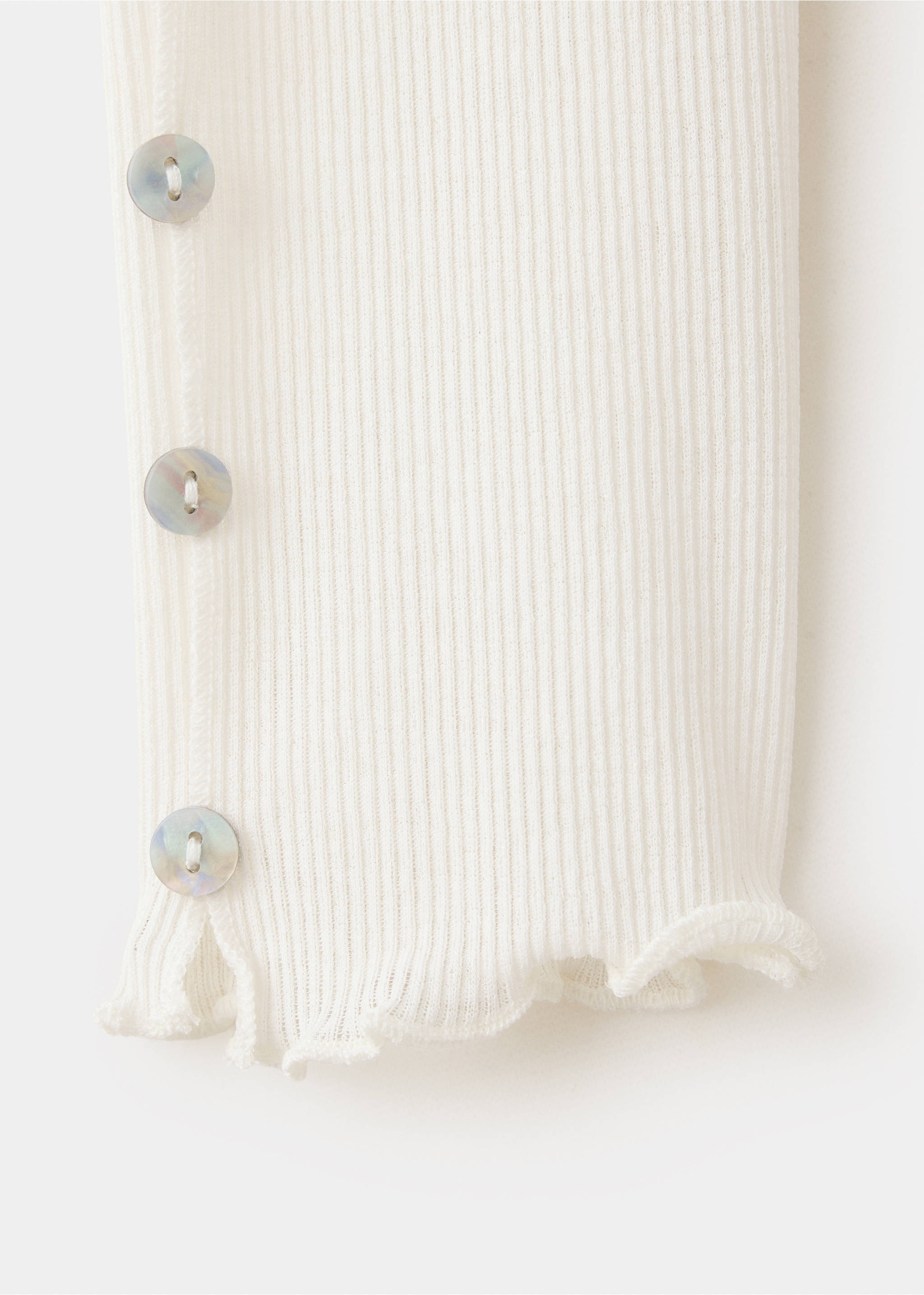 Primer plano del puño de camiseta canalé en color blanco roto con botones perlados., Blanco. Ref: 37047810-00.