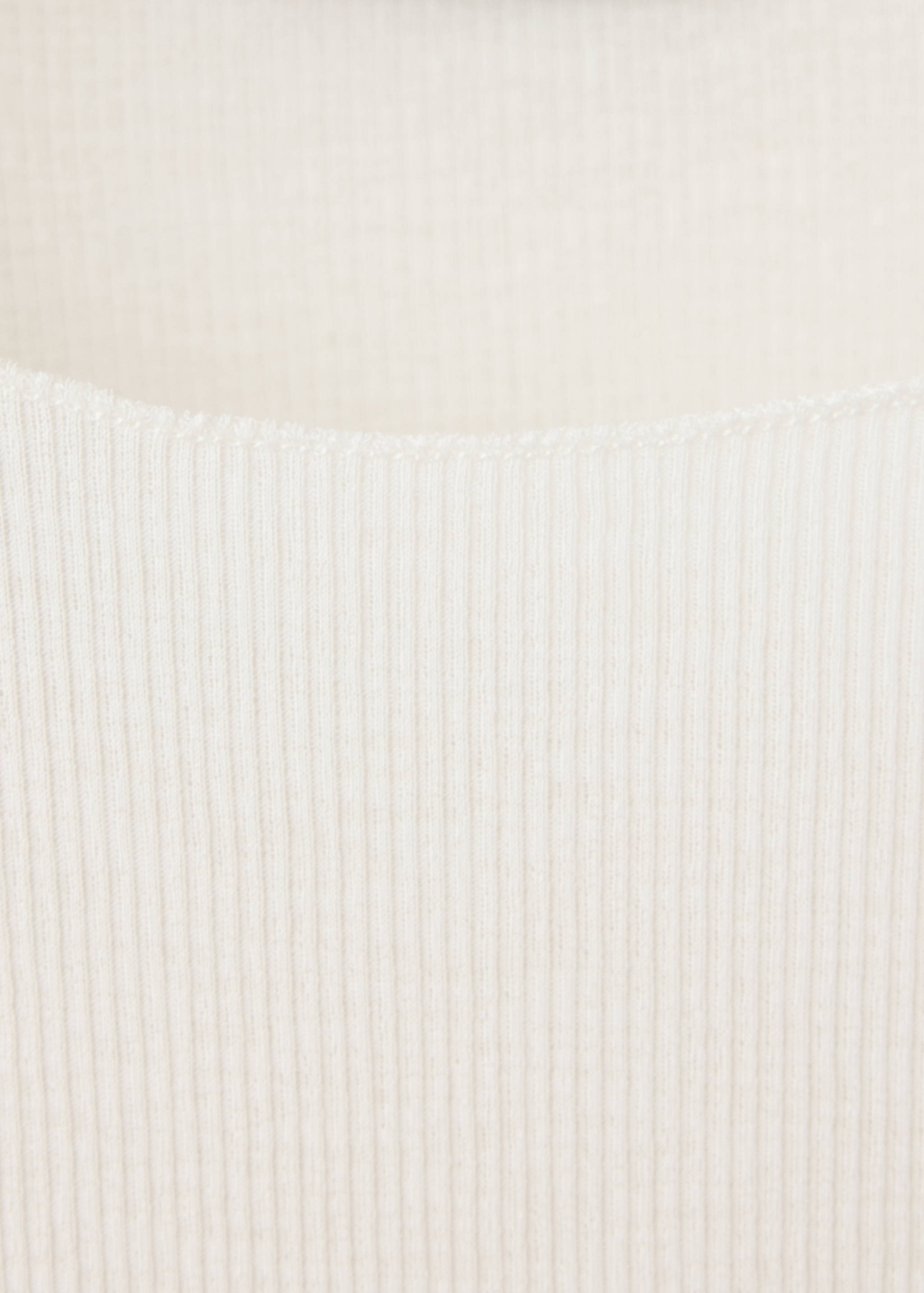 Primer plano de la textura del tejido de la camiseta de canalé en color blanco roto.