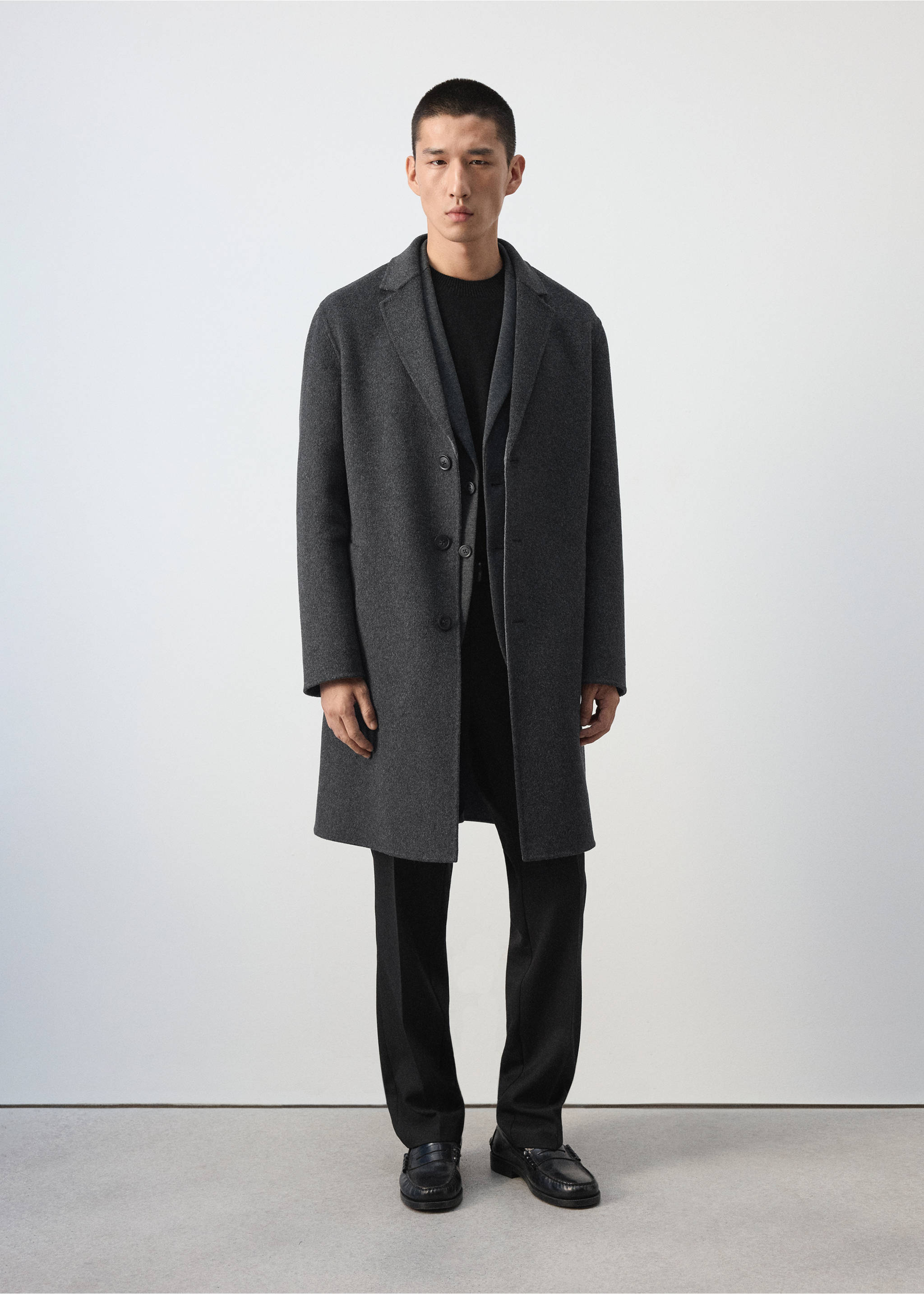 Dark grey coat with a lapel collar and button closure, worn with a black top and trousers., Charcoal. Ref: 37047886-00.